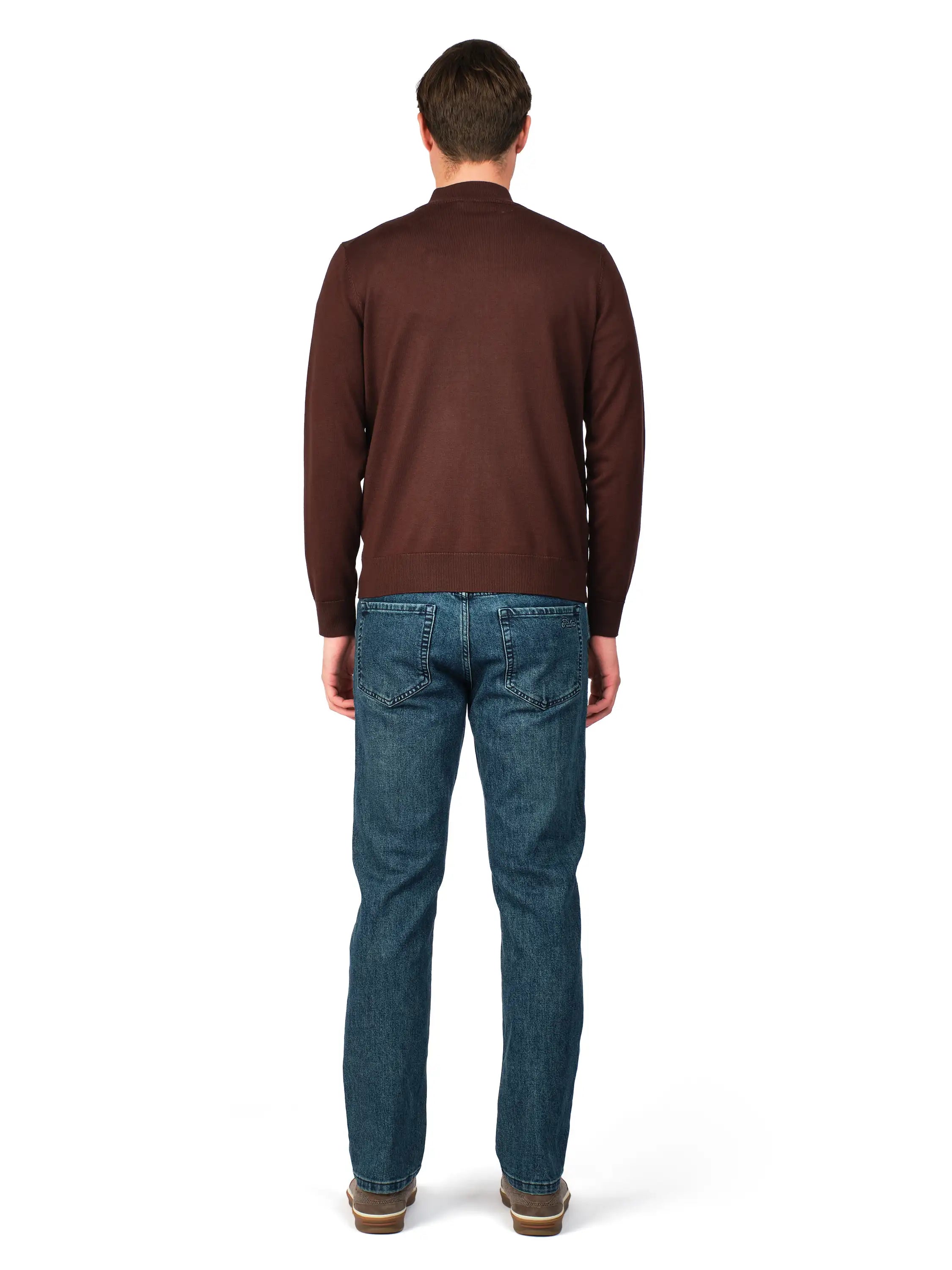 Man wearing a brown sweater and blue jeans on a white background