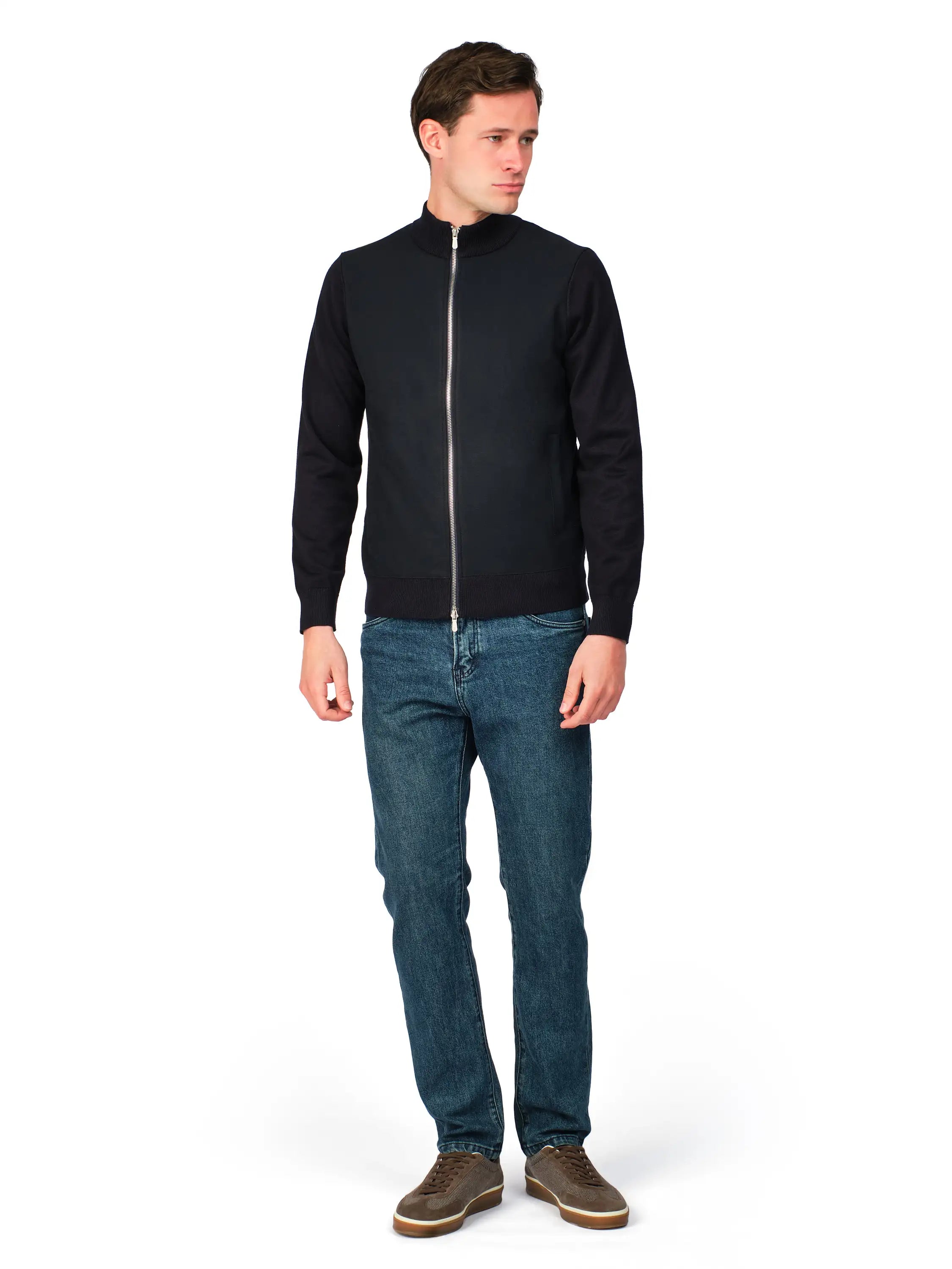Man wearing a black jacket and blue jeans on a white background