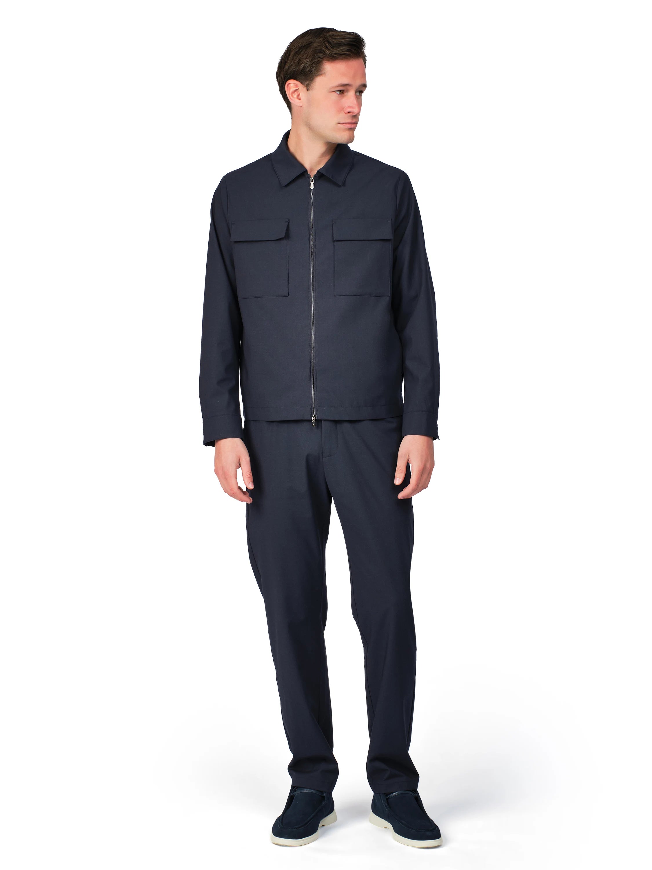 Man wearing a navy blue jacket and pants on a white background