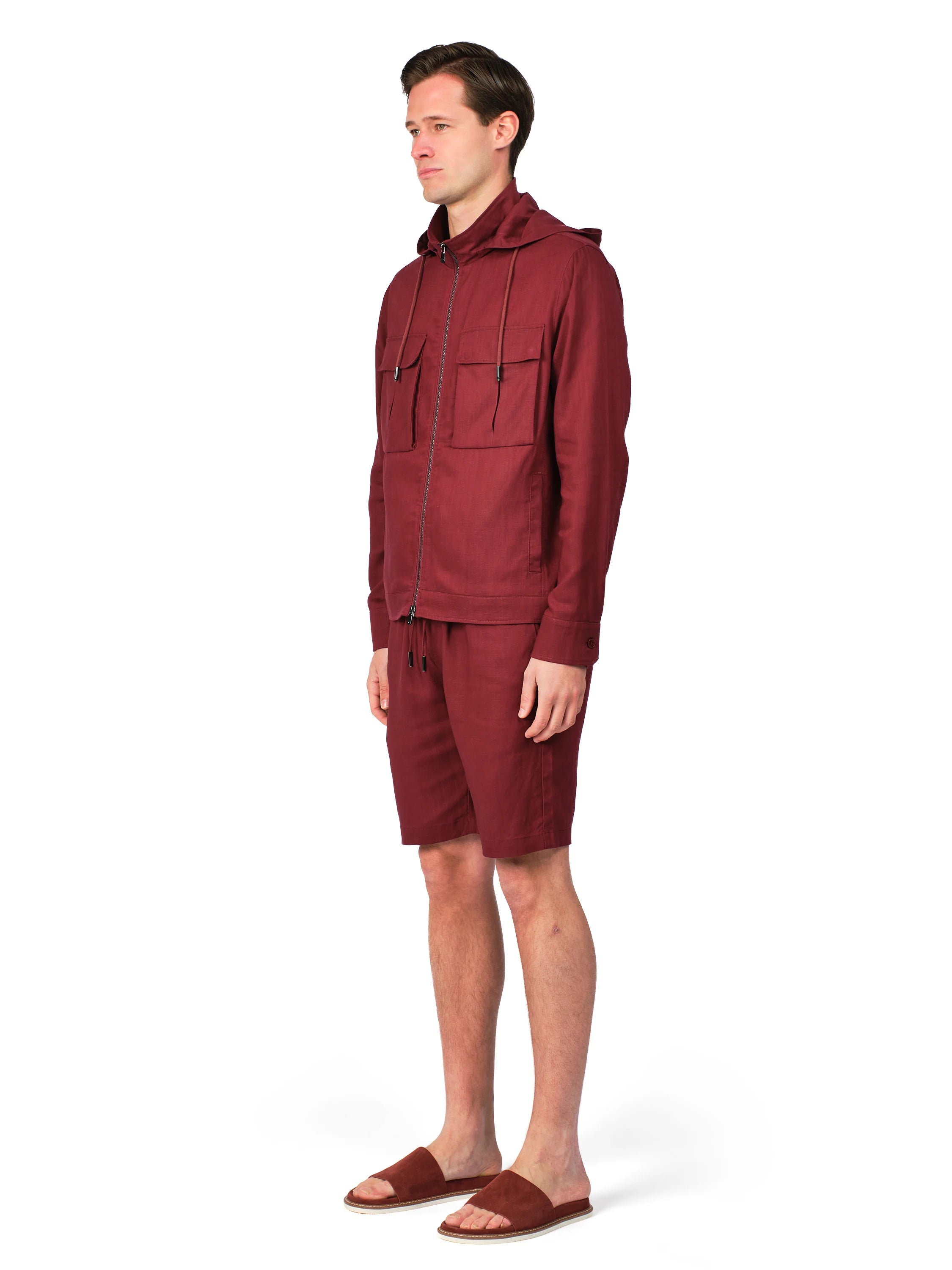 Man wearing a maroon hoodie and shorts on a white background