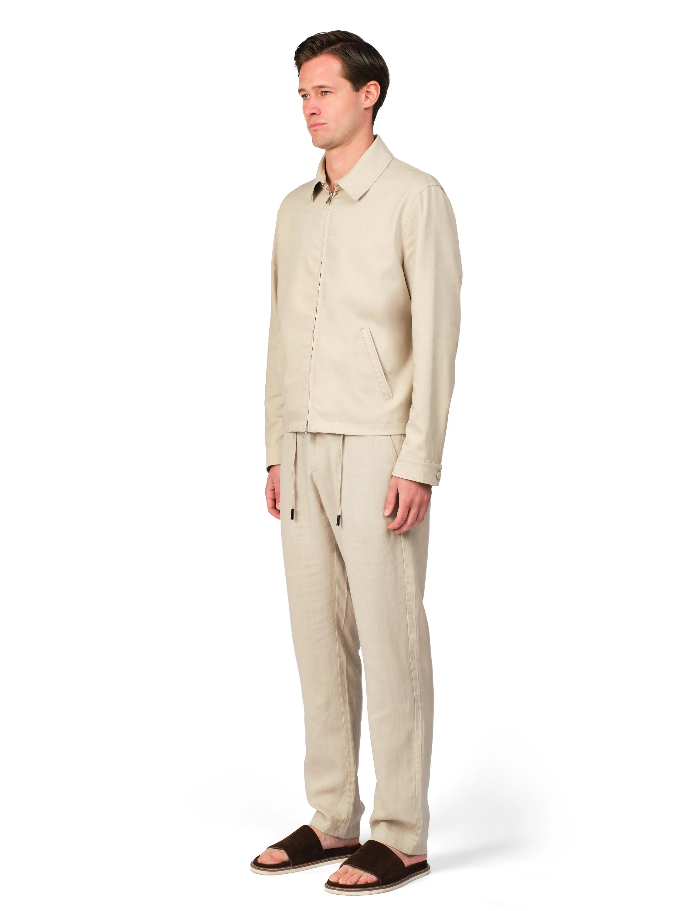 Man wearing a beige linen suit on a white background