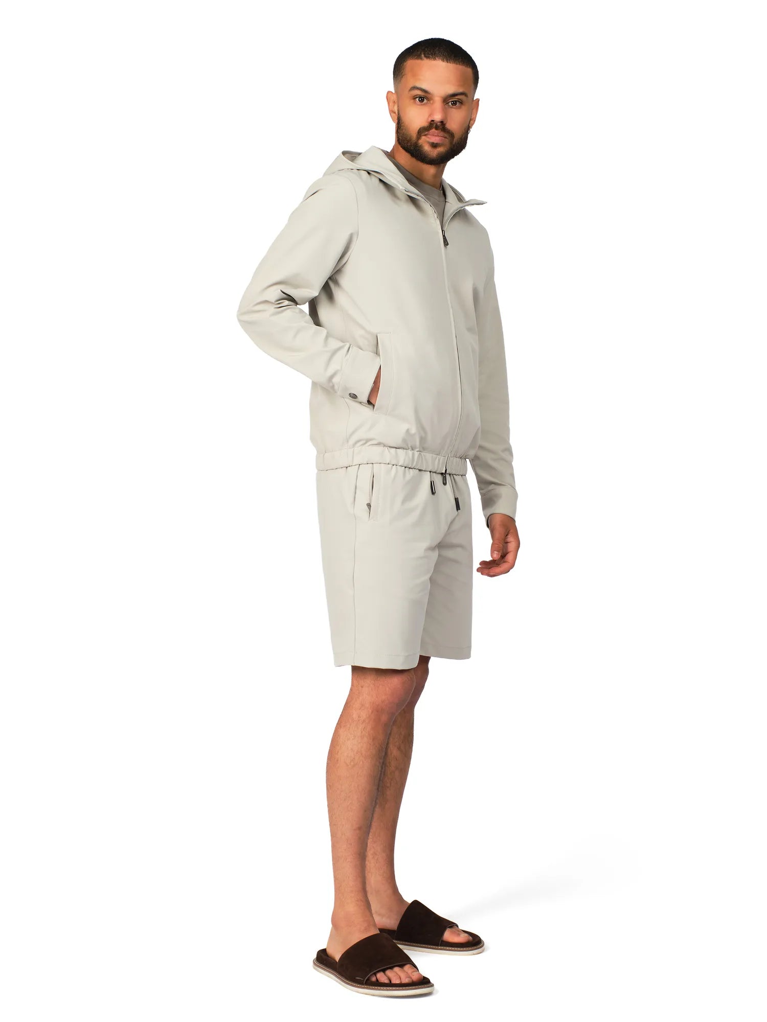 Man wearing a light gray hoodie and shorts set on a white background