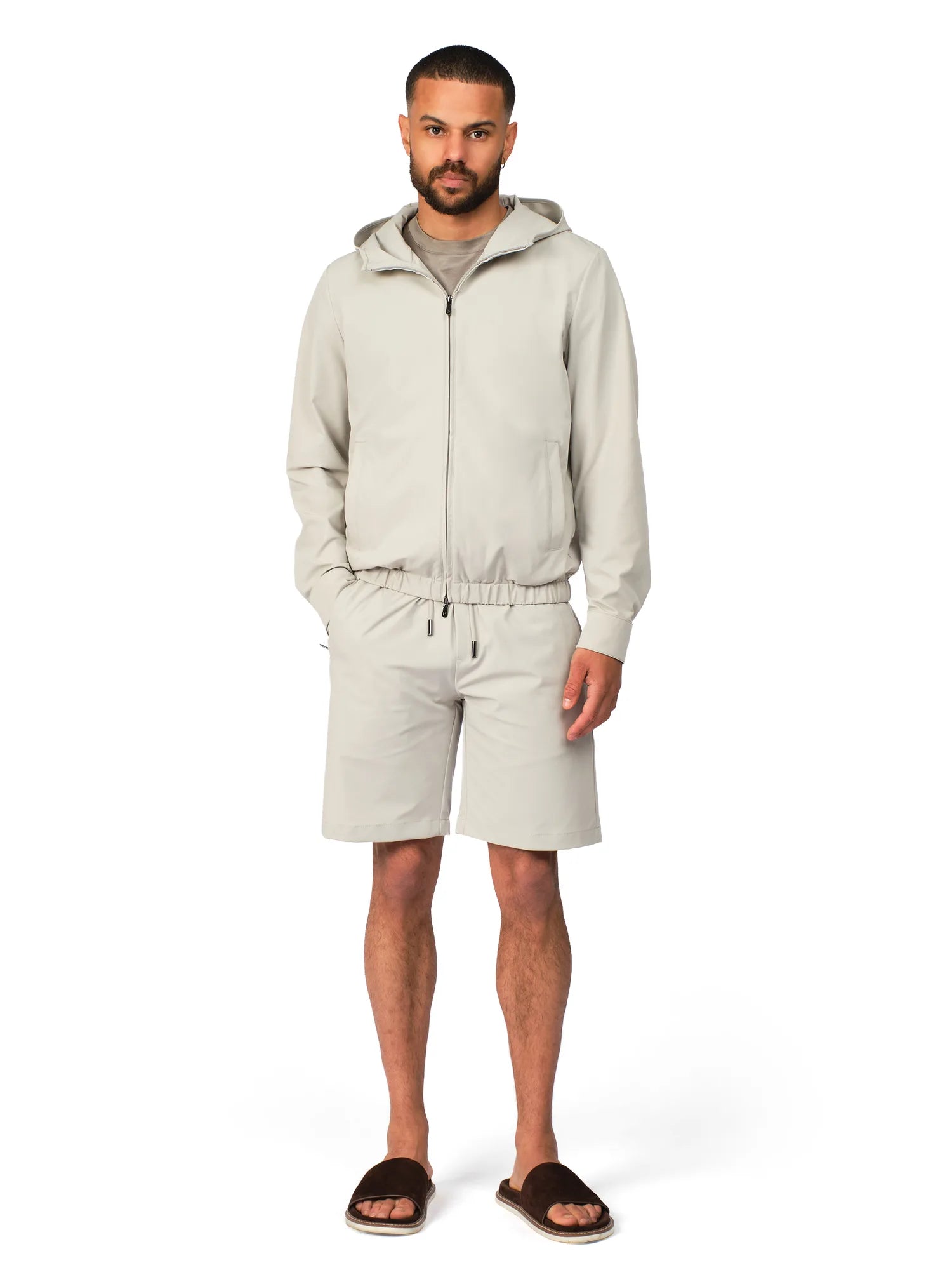 Man wearing a beige tracksuit on a white background