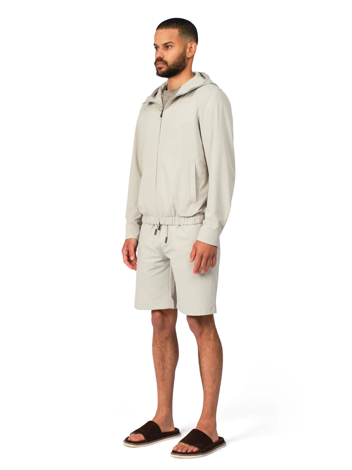 Man wearing a beige tracksuit on a white background