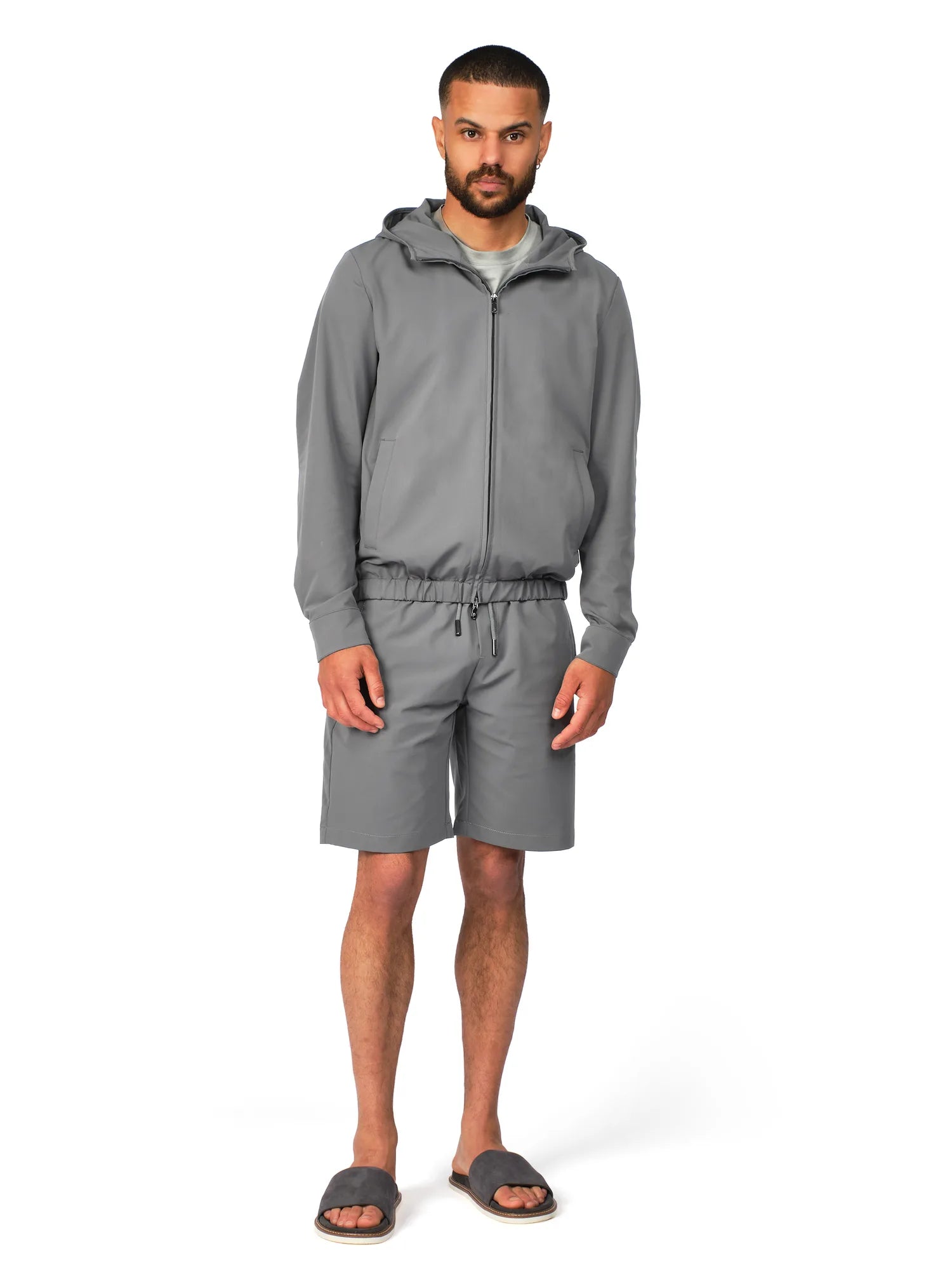 Man wearing a gray hoodie and shorts set on a white background