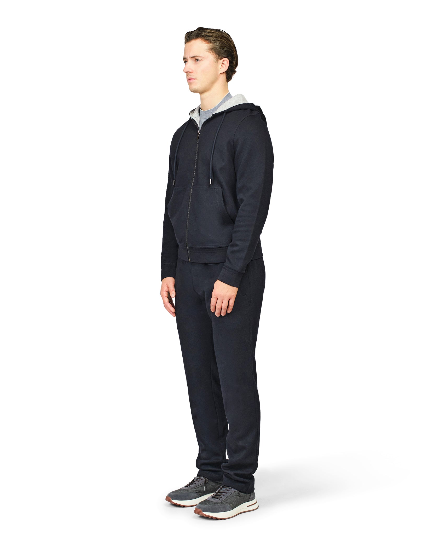 Man wearing a dark blue tracksuit on a white background
