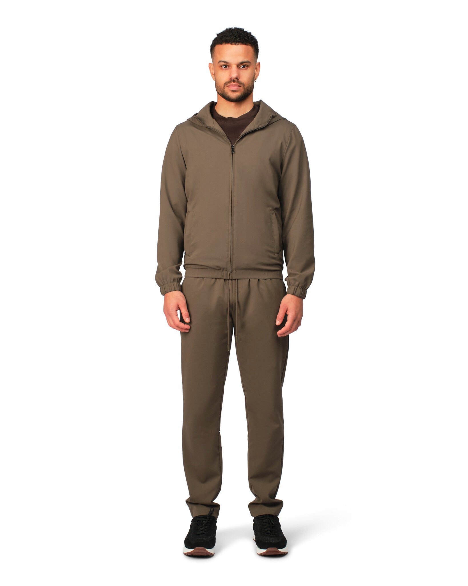 Man wearing a brown tracksuit on a white background