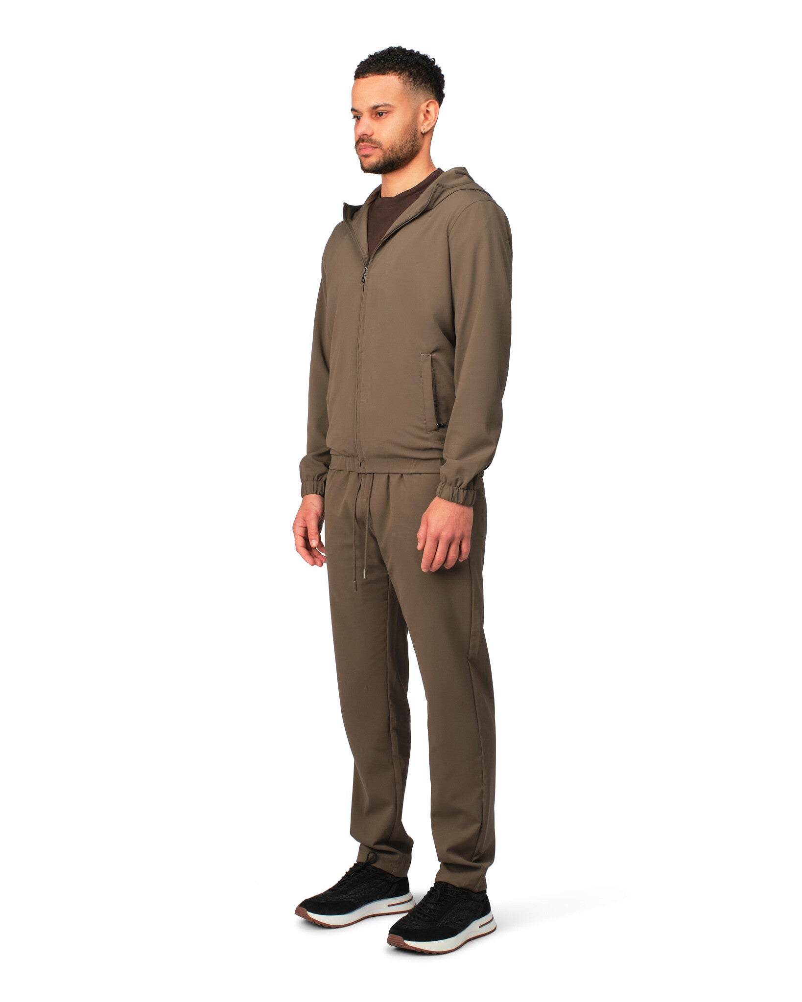 Man wearing a brown tracksuit on a white background