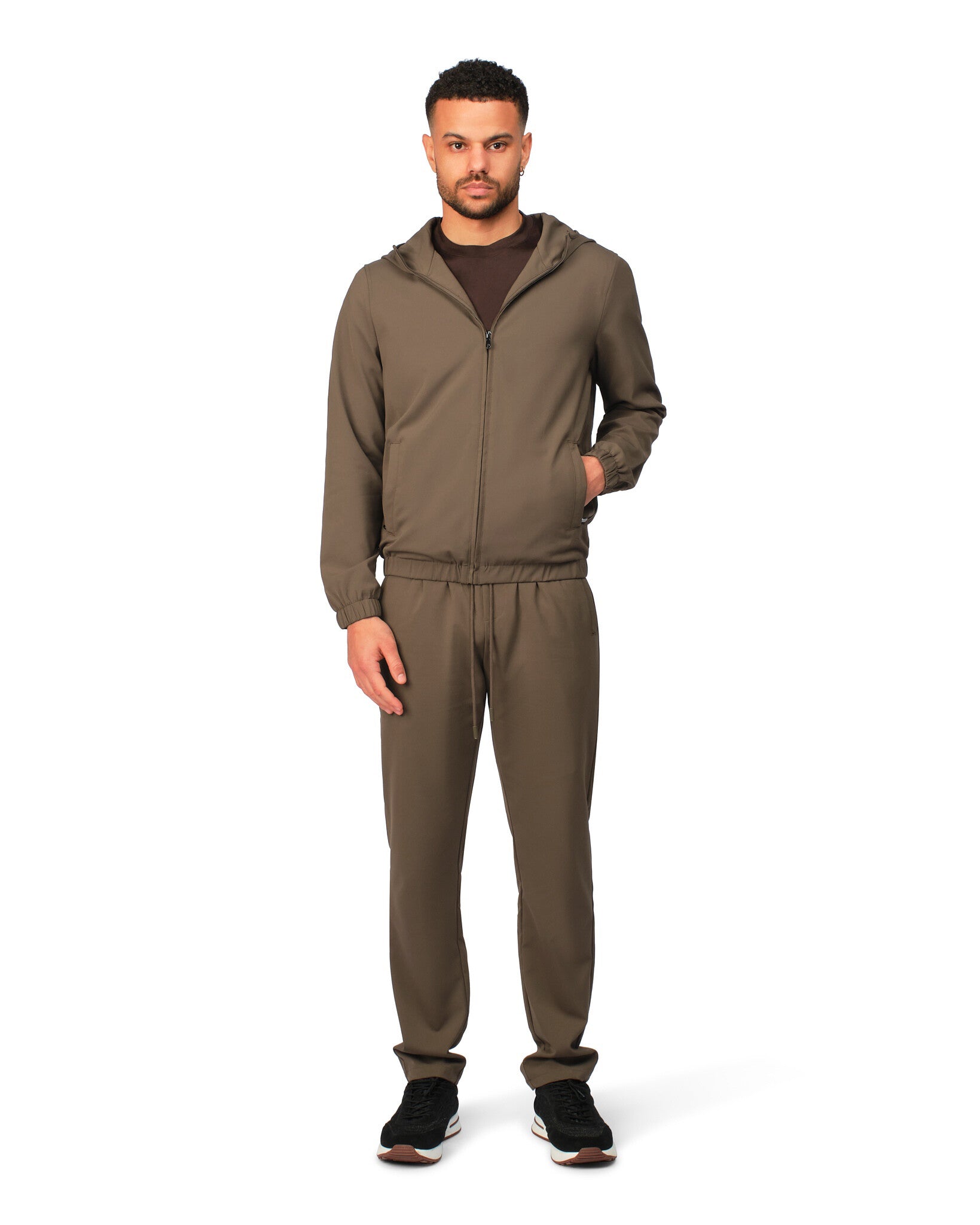 Man wearing a brown tracksuit on a white background