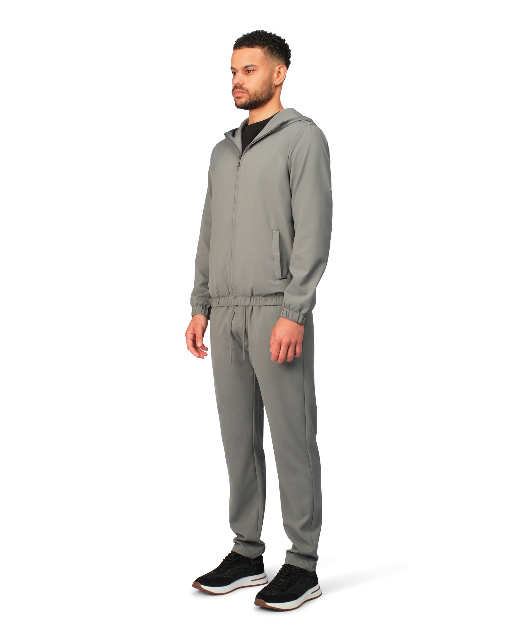 Man wearing a gray tracksuit on a white background