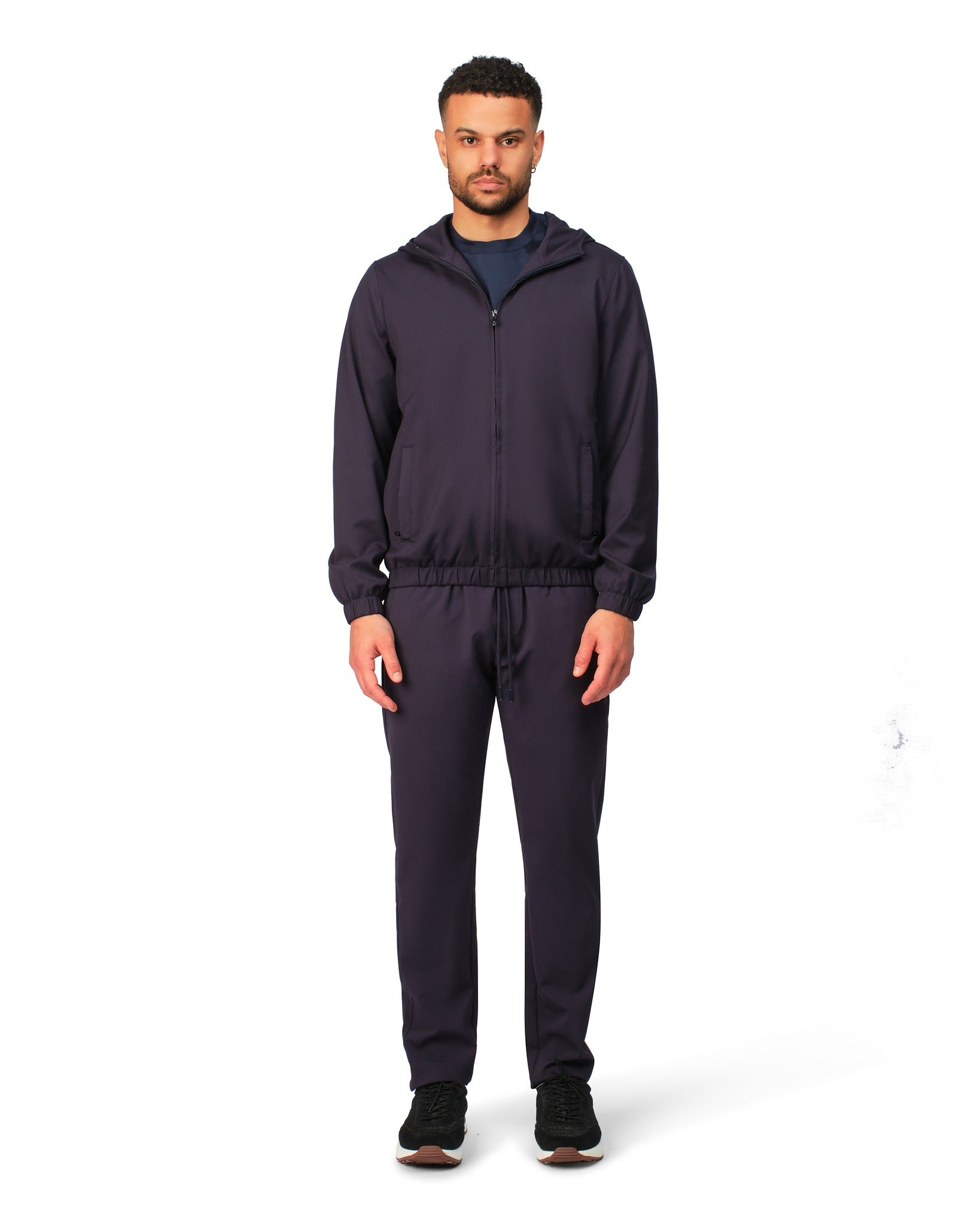 Man wearing a navy tracksuit on a white background