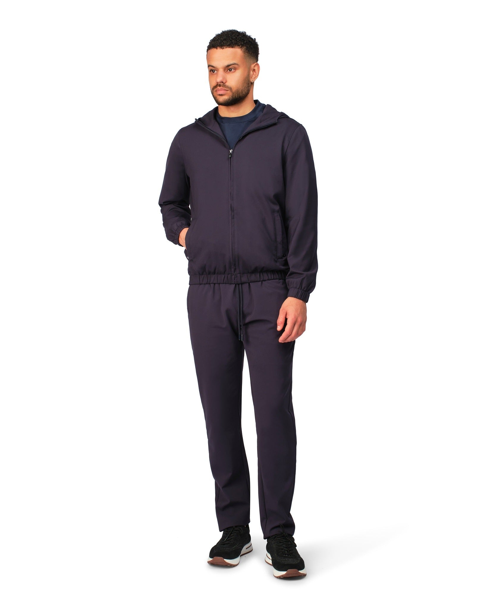 Man wearing a navy tracksuit on a white background