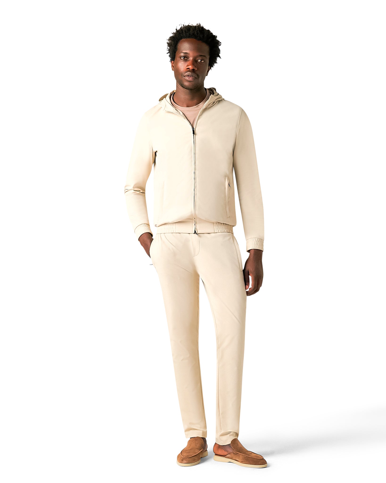 Man wearing a beige tracksuit on a white background