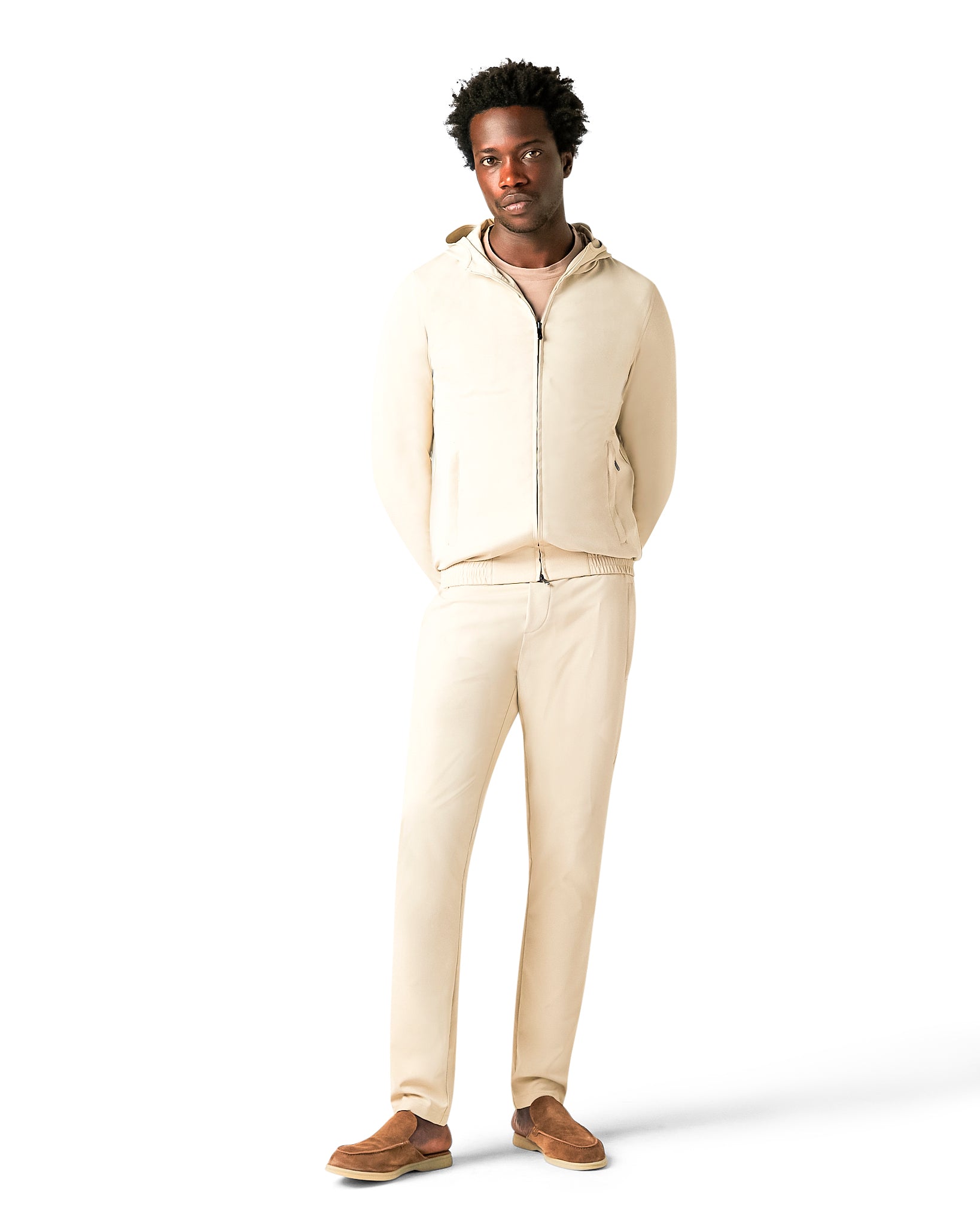 Man wearing a beige hoodie and pants on a white background
