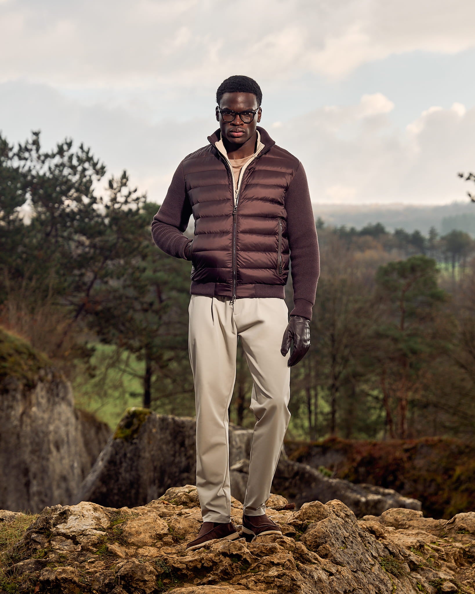 De gebreide donsjas met mouwen in bruin