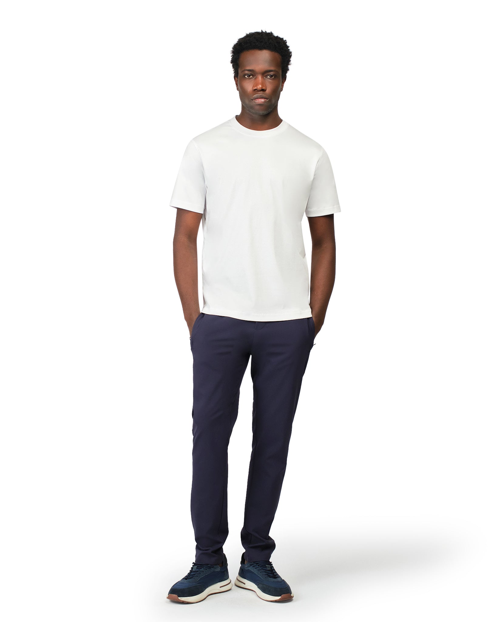 Man wearing a white t-shirt and navy pants on a white background