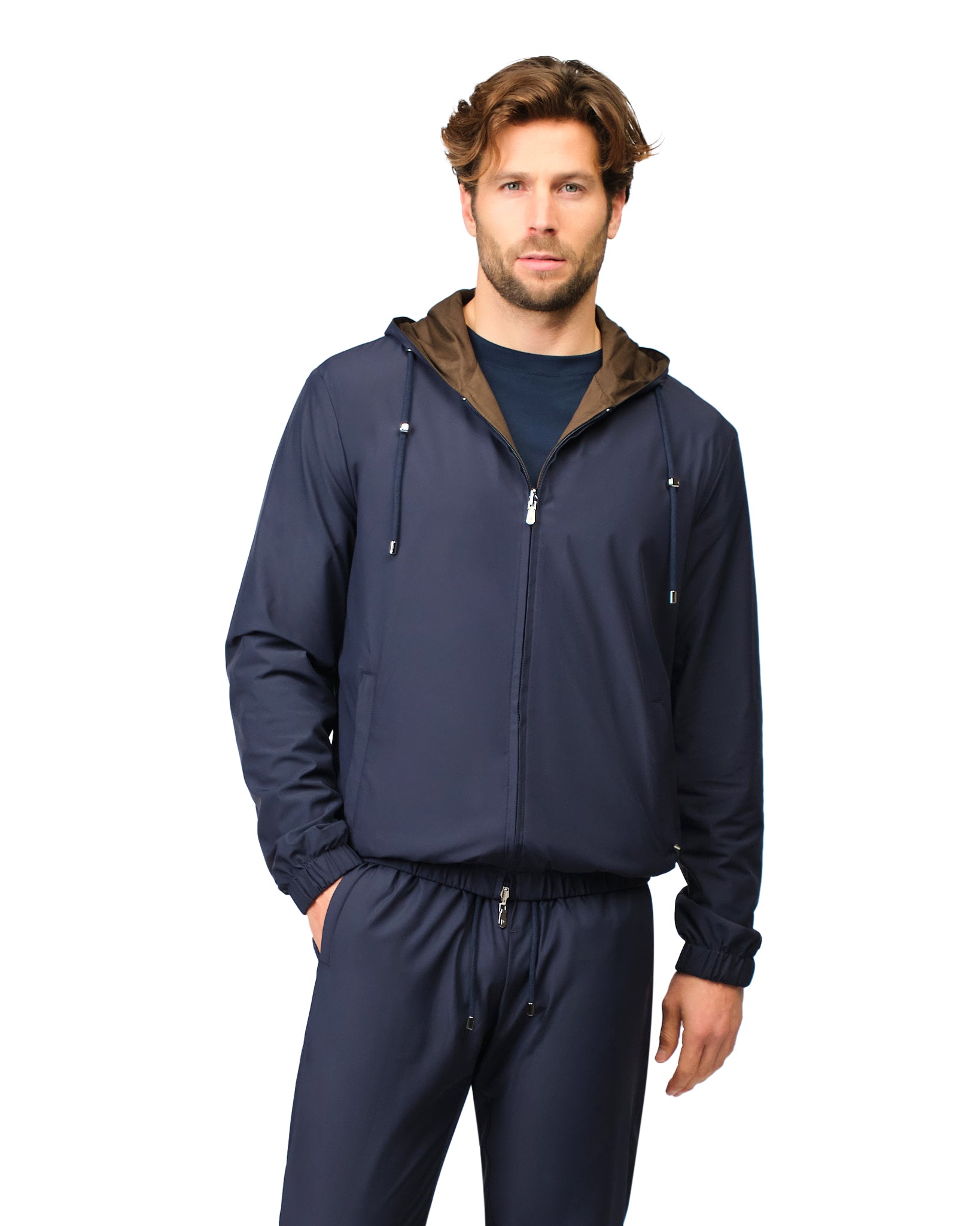 Man wearing a navy blue jacket with a brown hood on a white background