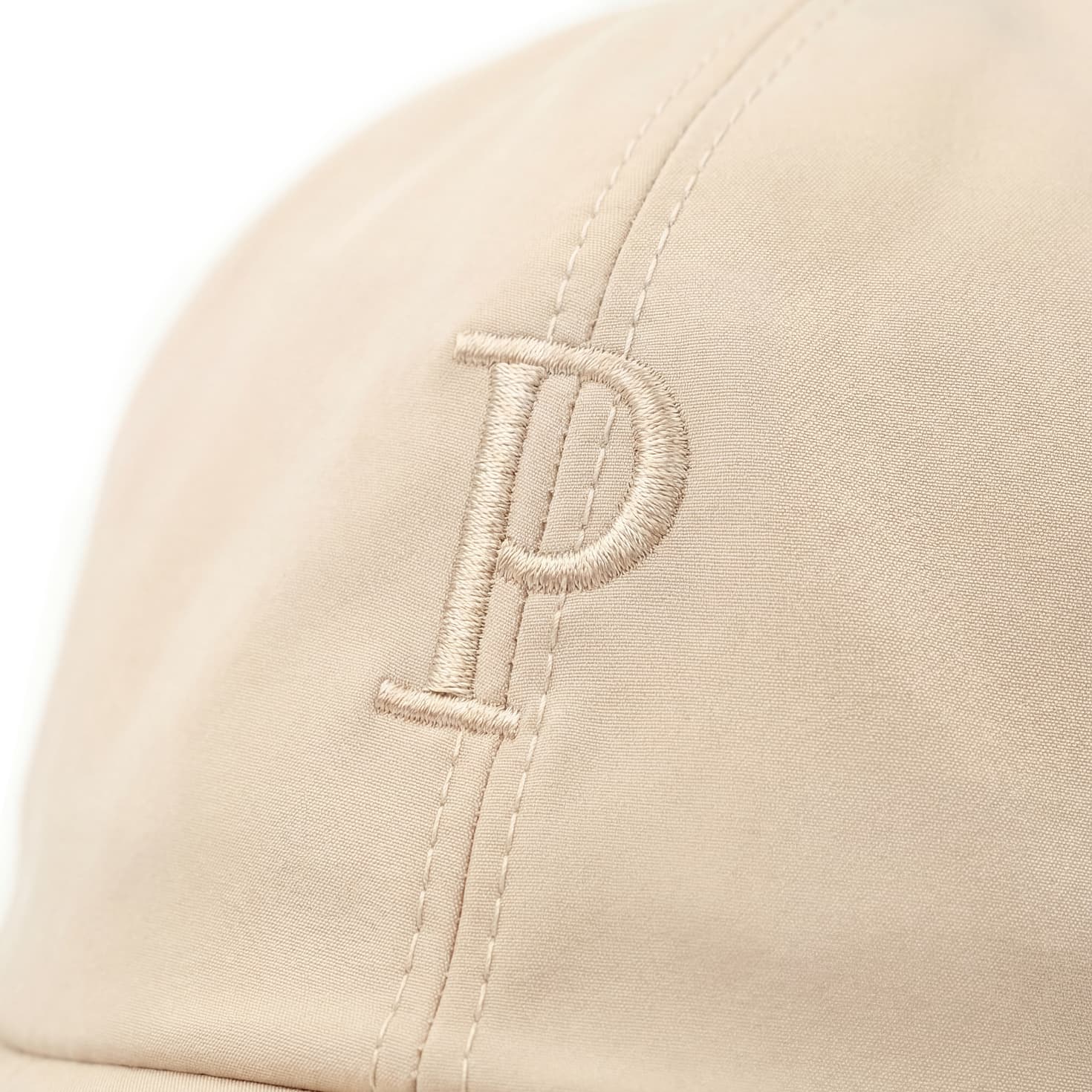 Beige cap with a letter 'P' embroidery on a white background
