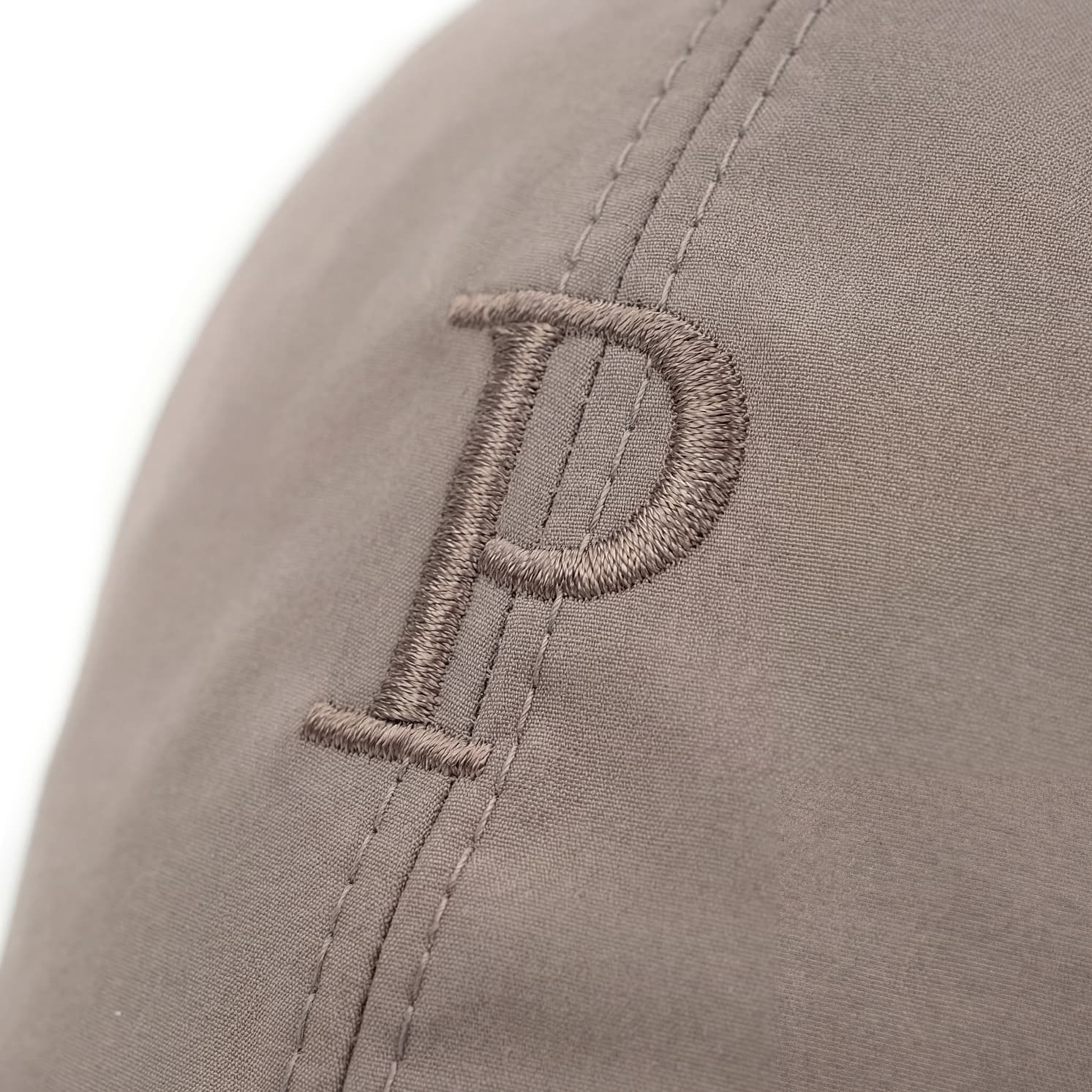 Close-up of a gray cap with an embroidered letter 'P' on a white background