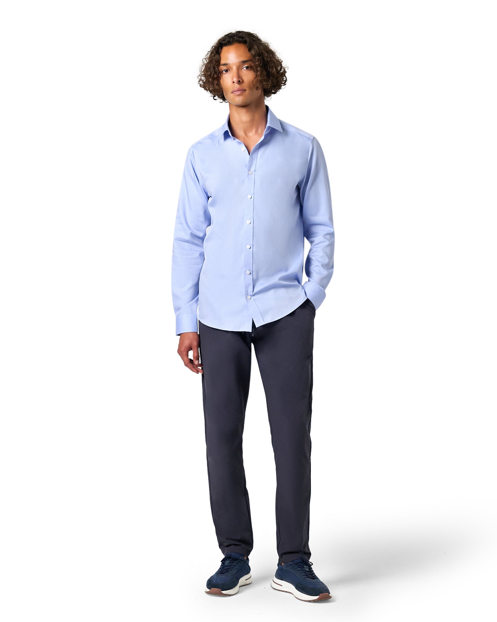 Man wearing a light blue shirt and dark pants