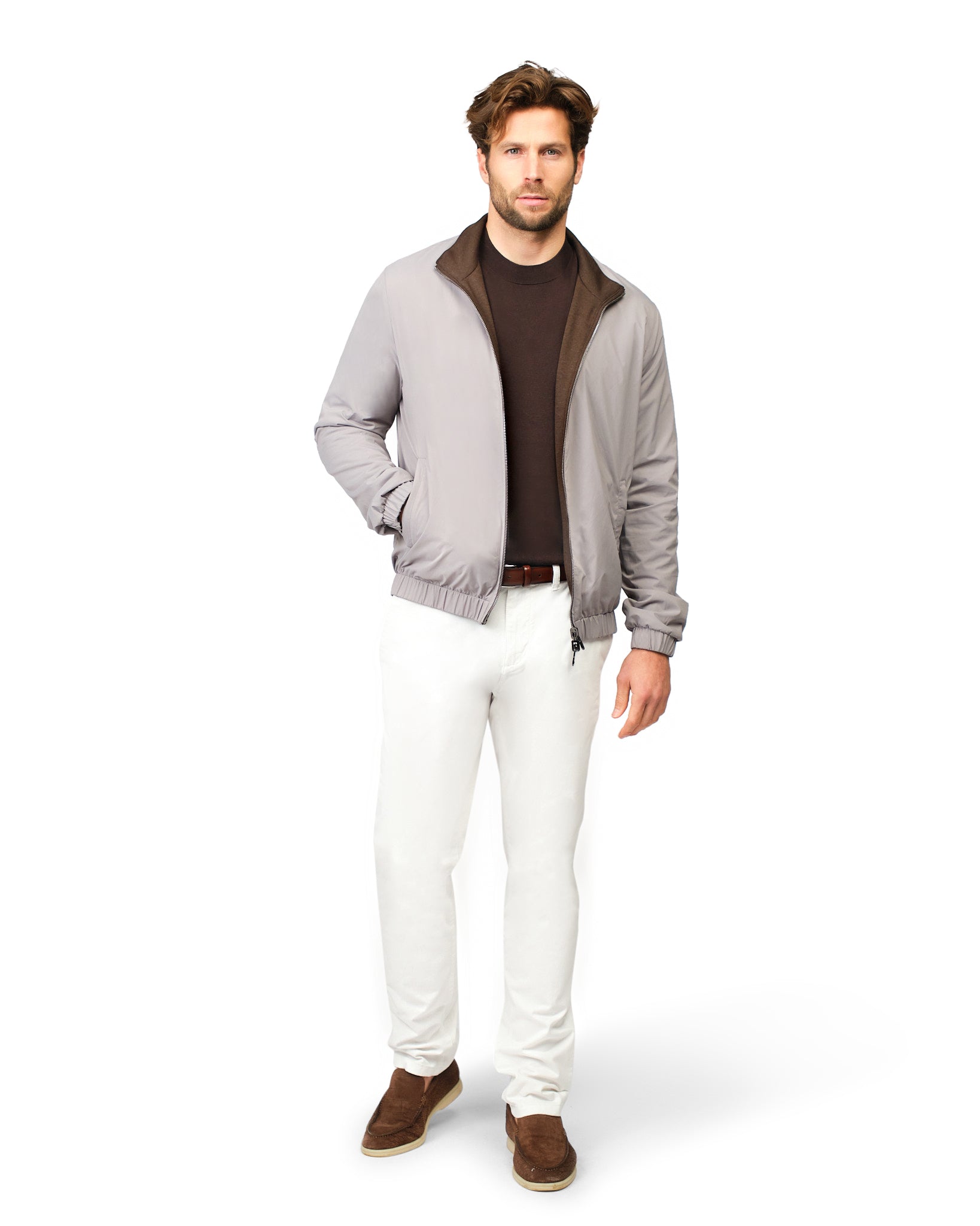 Man wearing a gray cardigan, brown shirt, white pants, and brown shoes