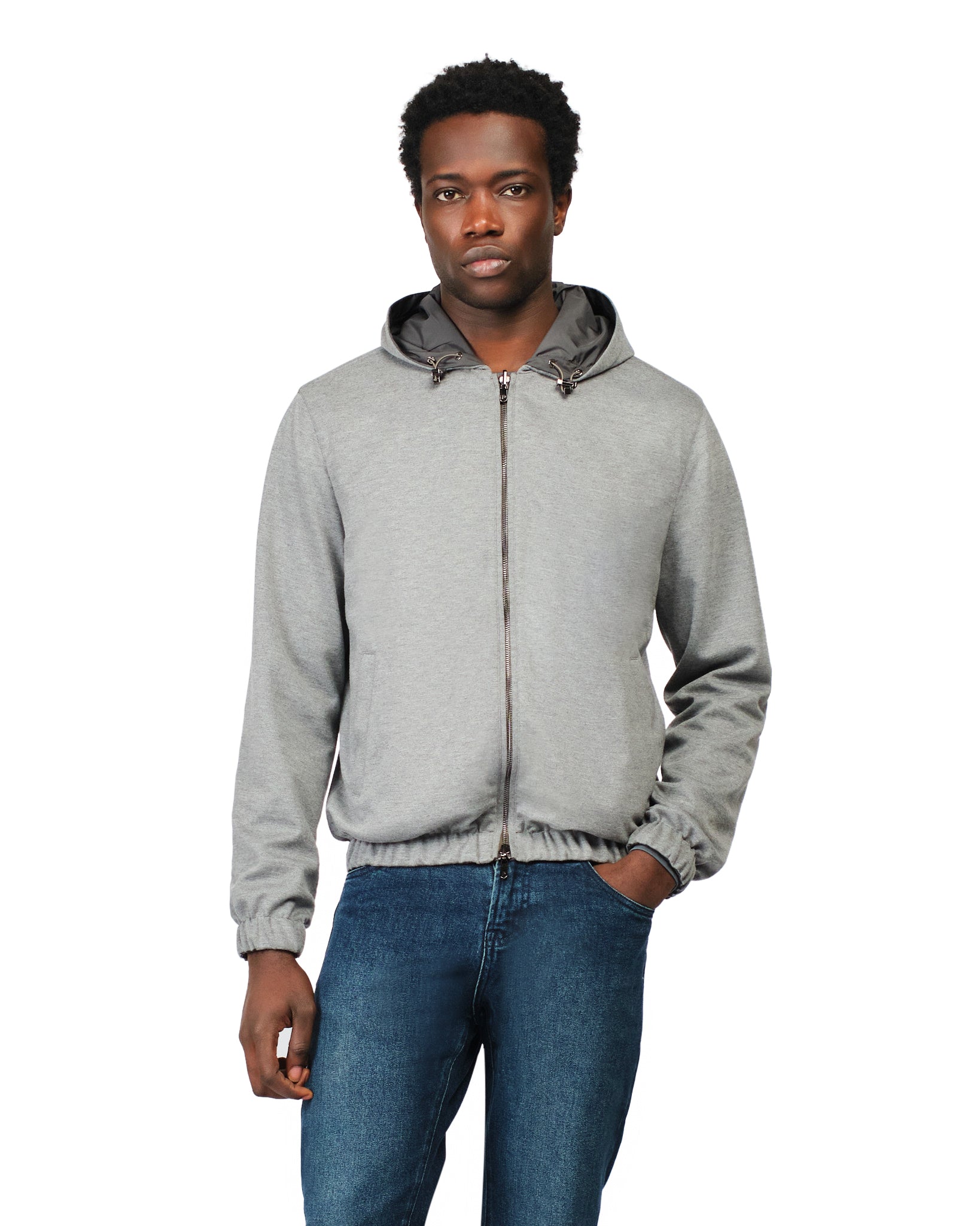 Man wearing a gray hoodie and blue jeans on a white background