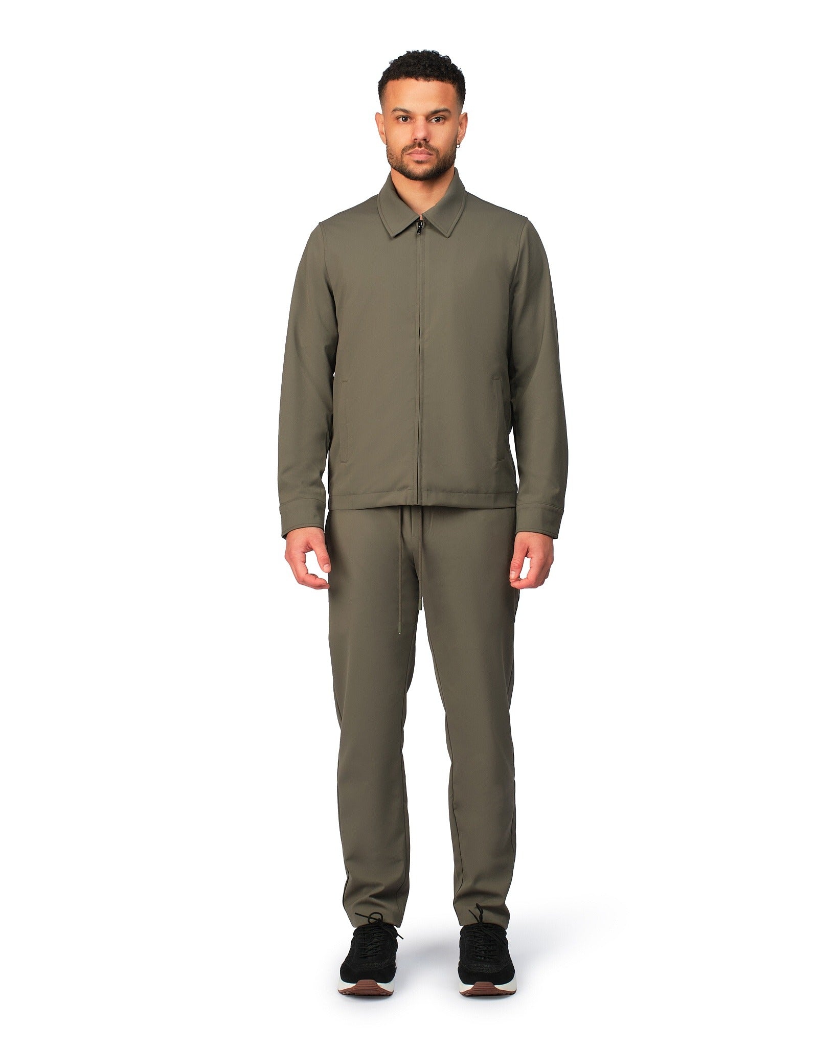 Green tech jacket with sleek design and zip closure, angled product view showing fit and details.