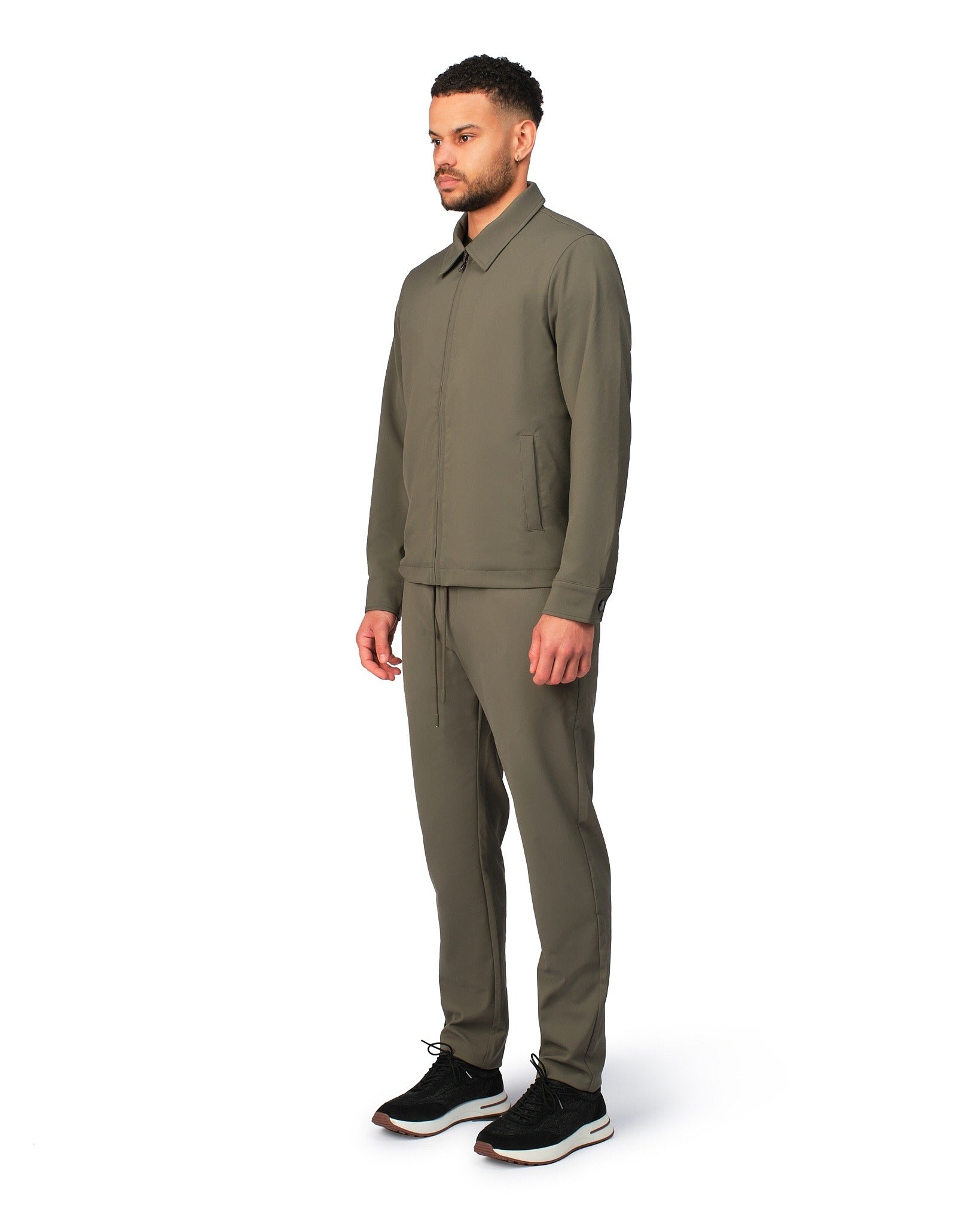 Green tech jacket with modern design and front zipper, detailed product view.