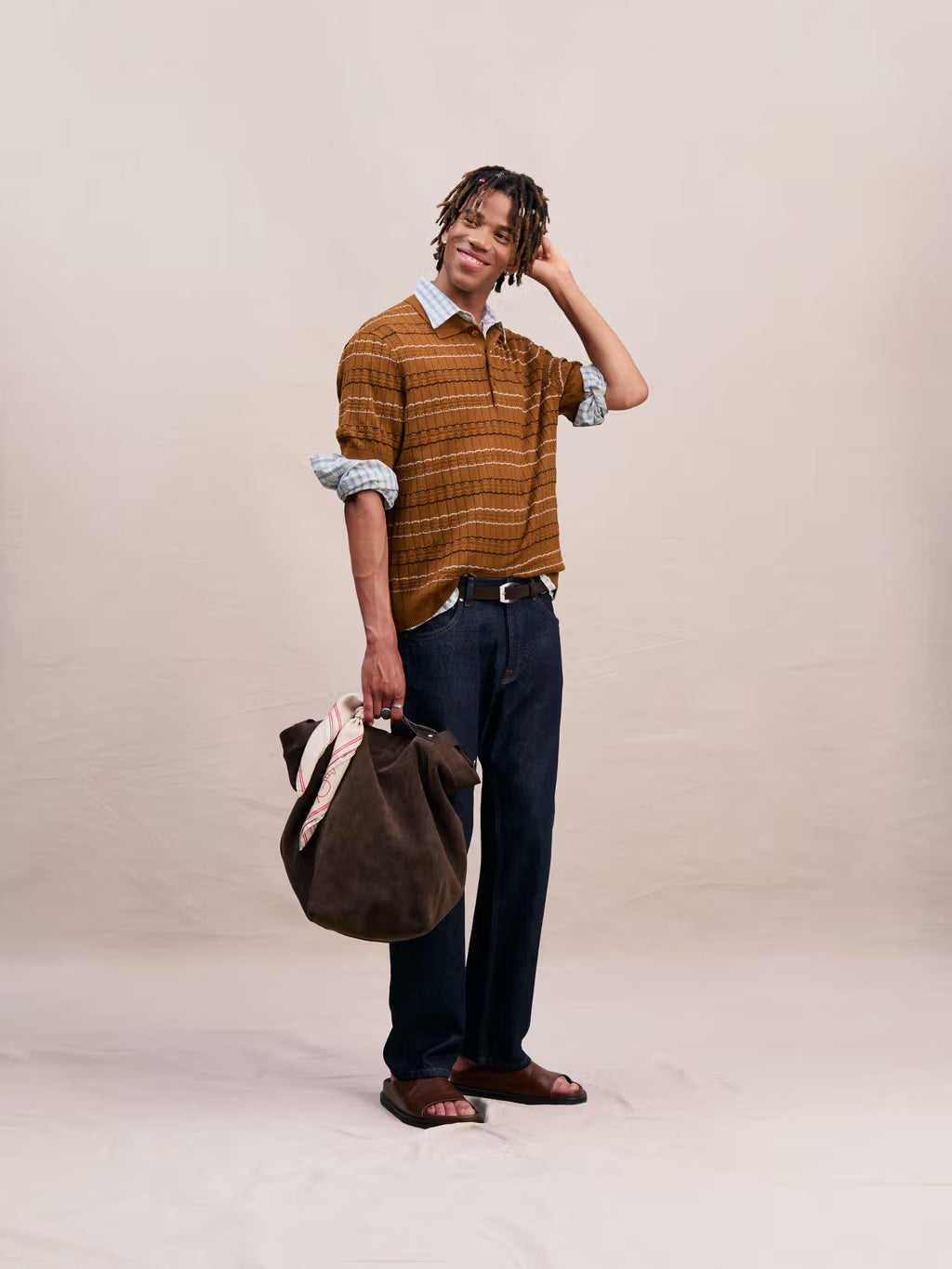 Person holding a brown bag against a plain background