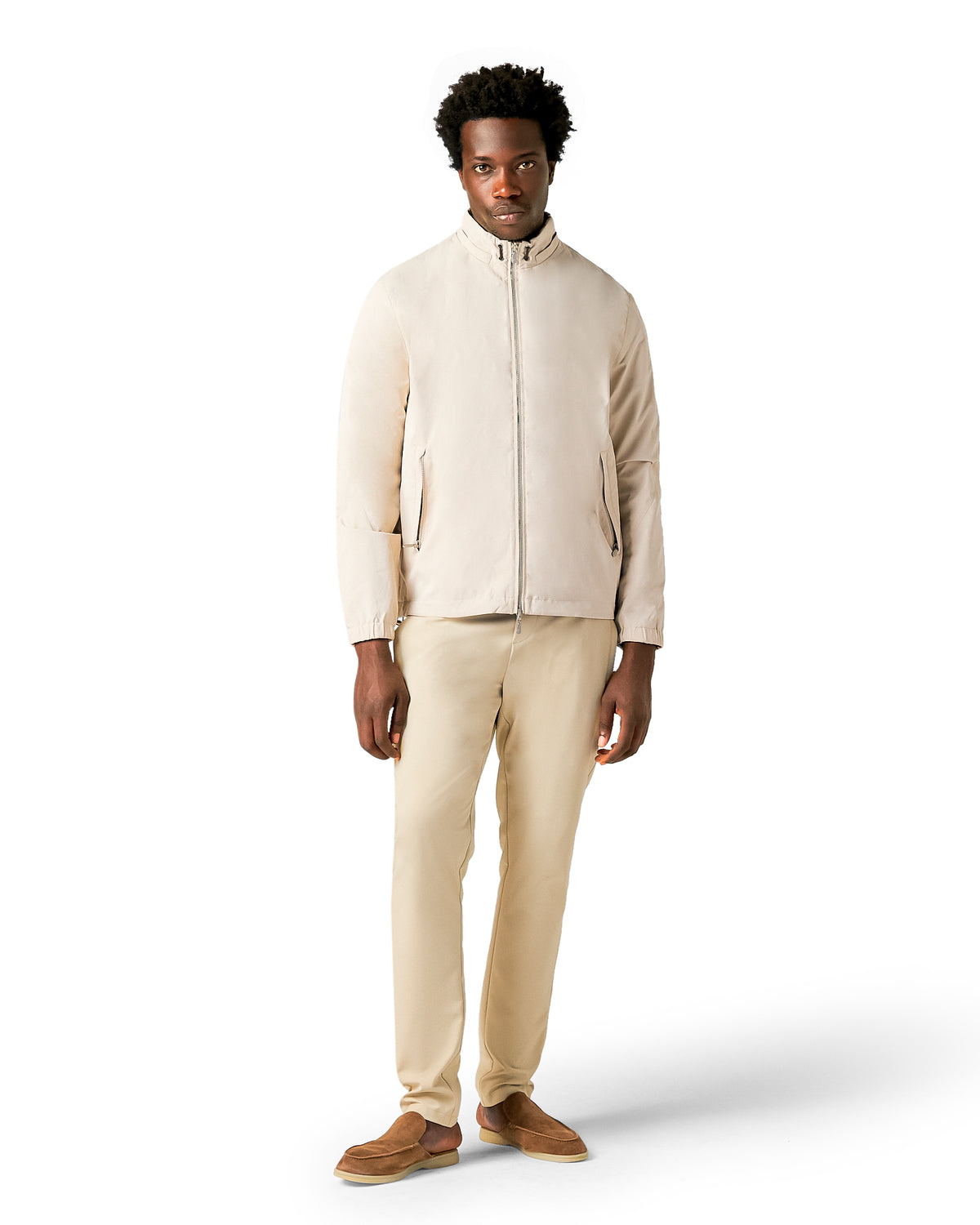 Man wearing a beige jacket and pants on a white background