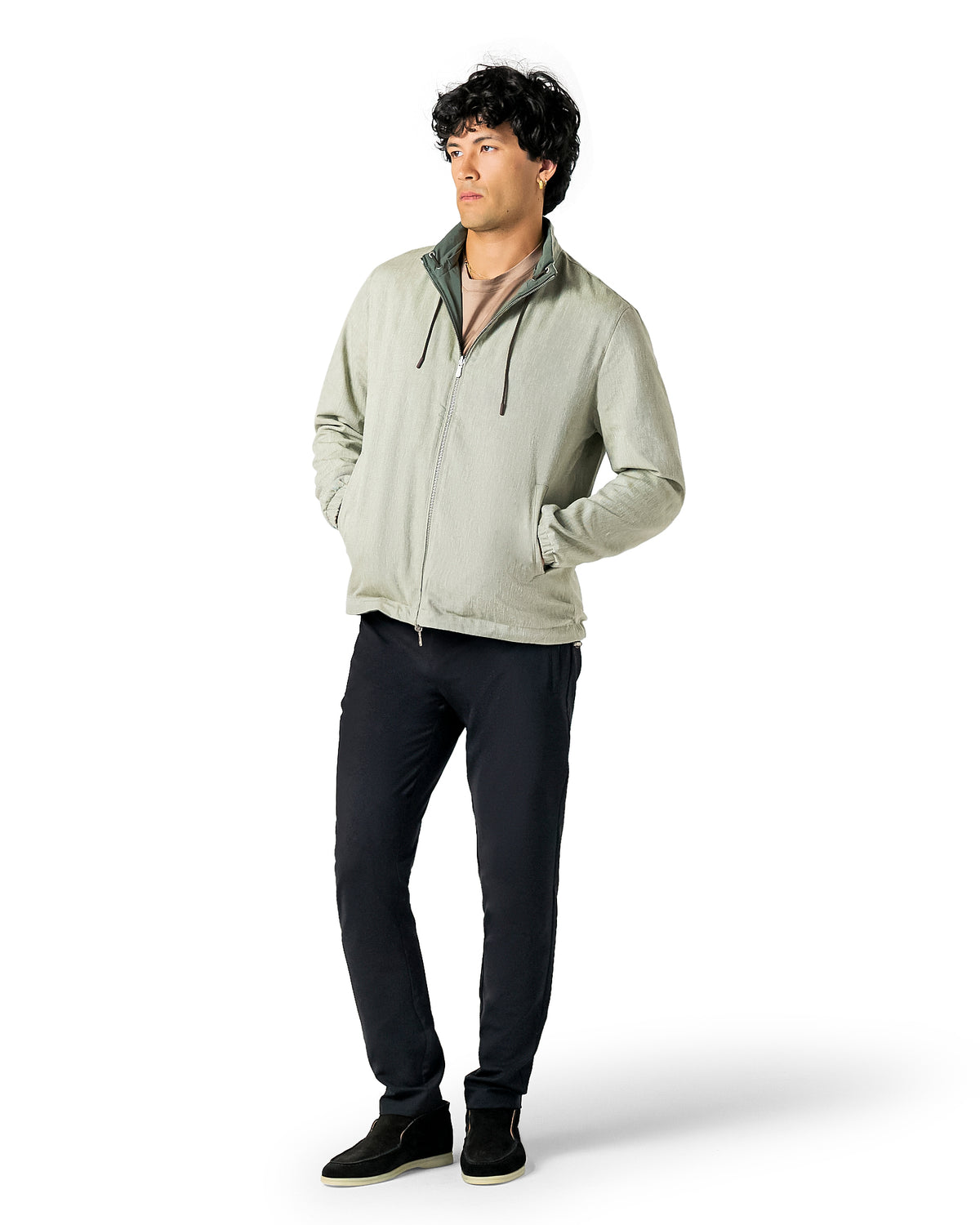 Man wearing a light gray jacket and dark pants on a white background