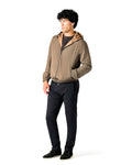 Man wearing a beige jacket and black pants on a white background