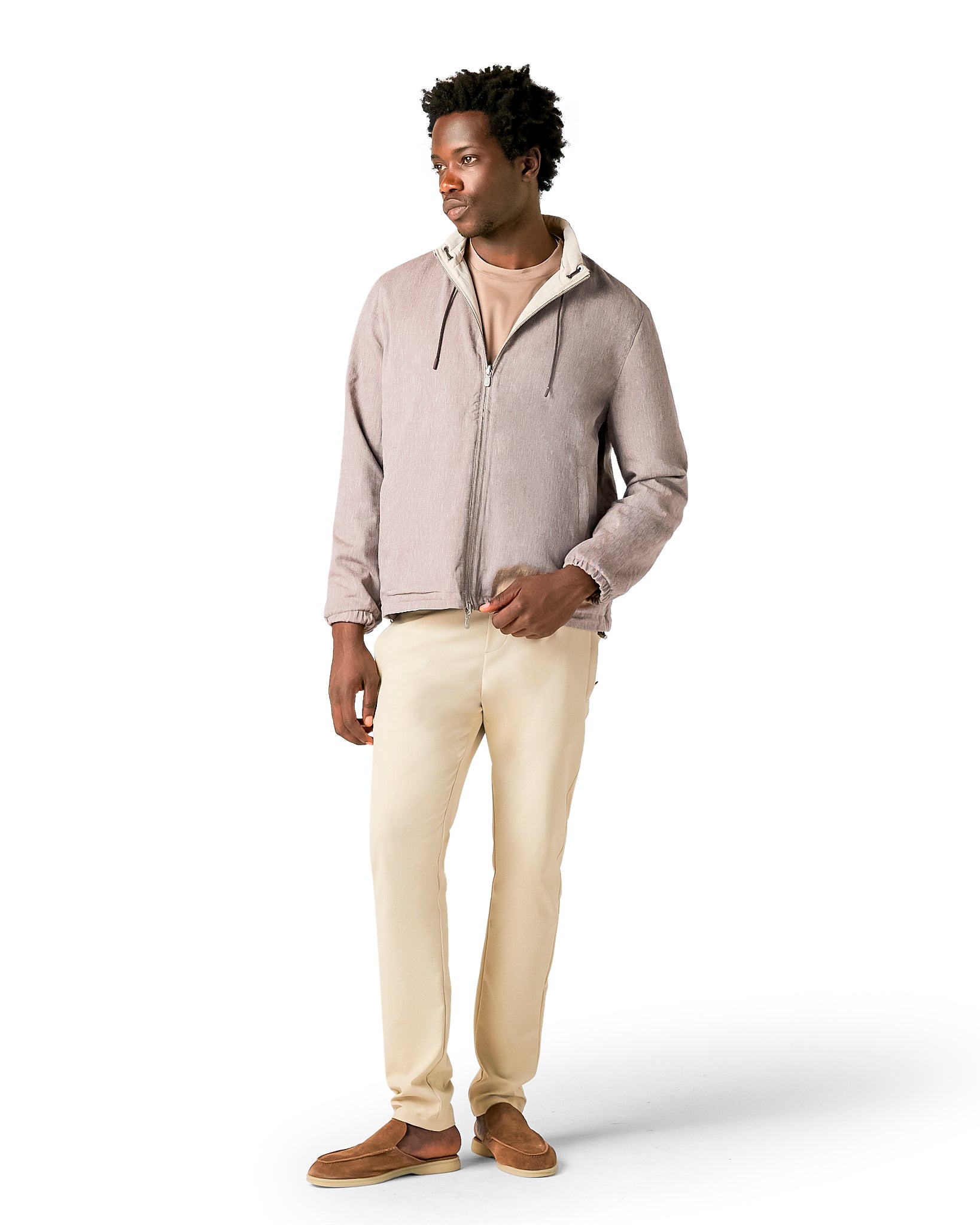 Man wearing a light gray hoodie and beige pants on a white background