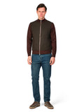 Man wearing a brown jacket and blue jeans on a white background