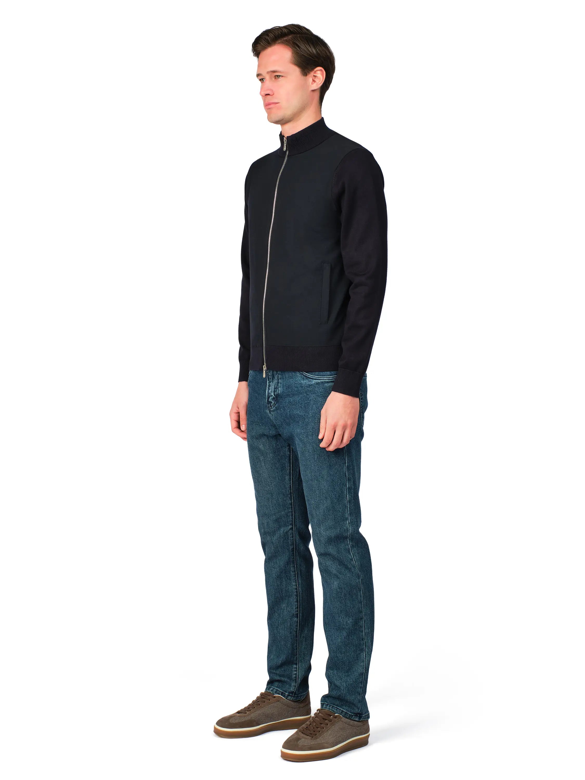 Man wearing a black jacket and blue jeans on a white background