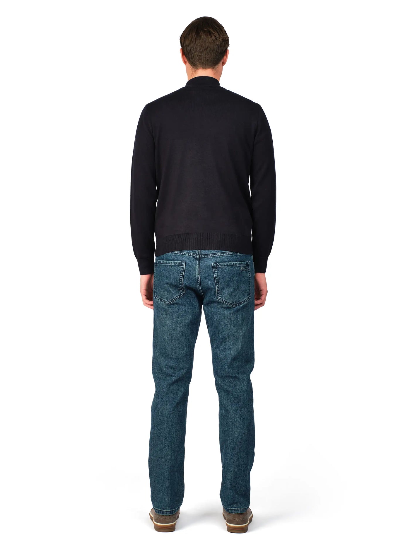 Man wearing a black sweater and blue jeans on a white background