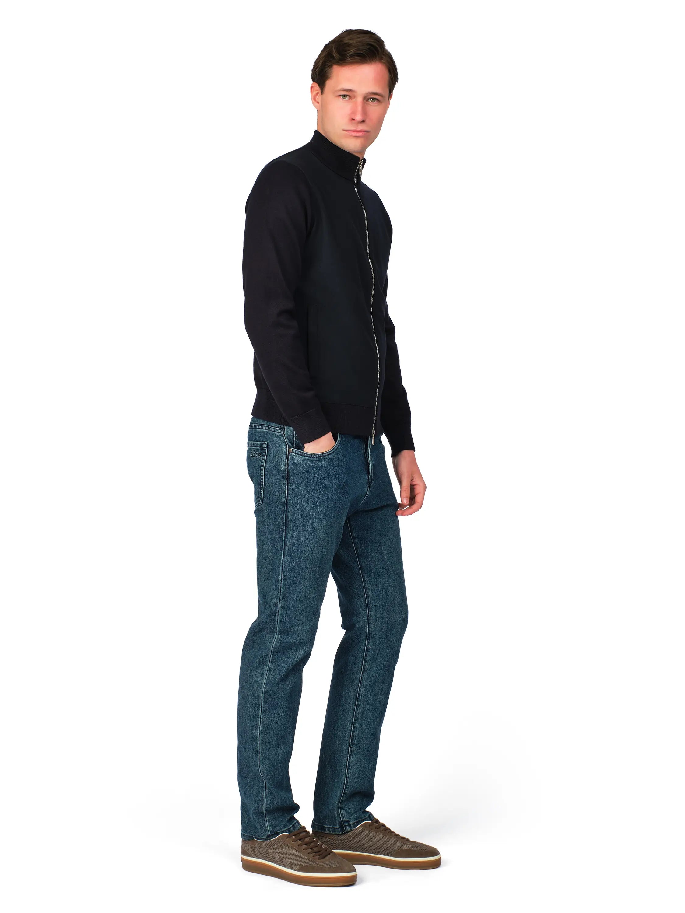 Man wearing a black jacket and blue jeans on a white background