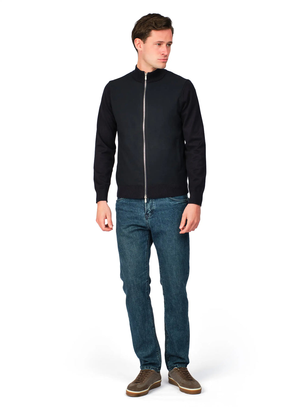 Man wearing a black jacket and blue jeans on a white background