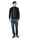 Man wearing a black jacket and blue jeans on a white background