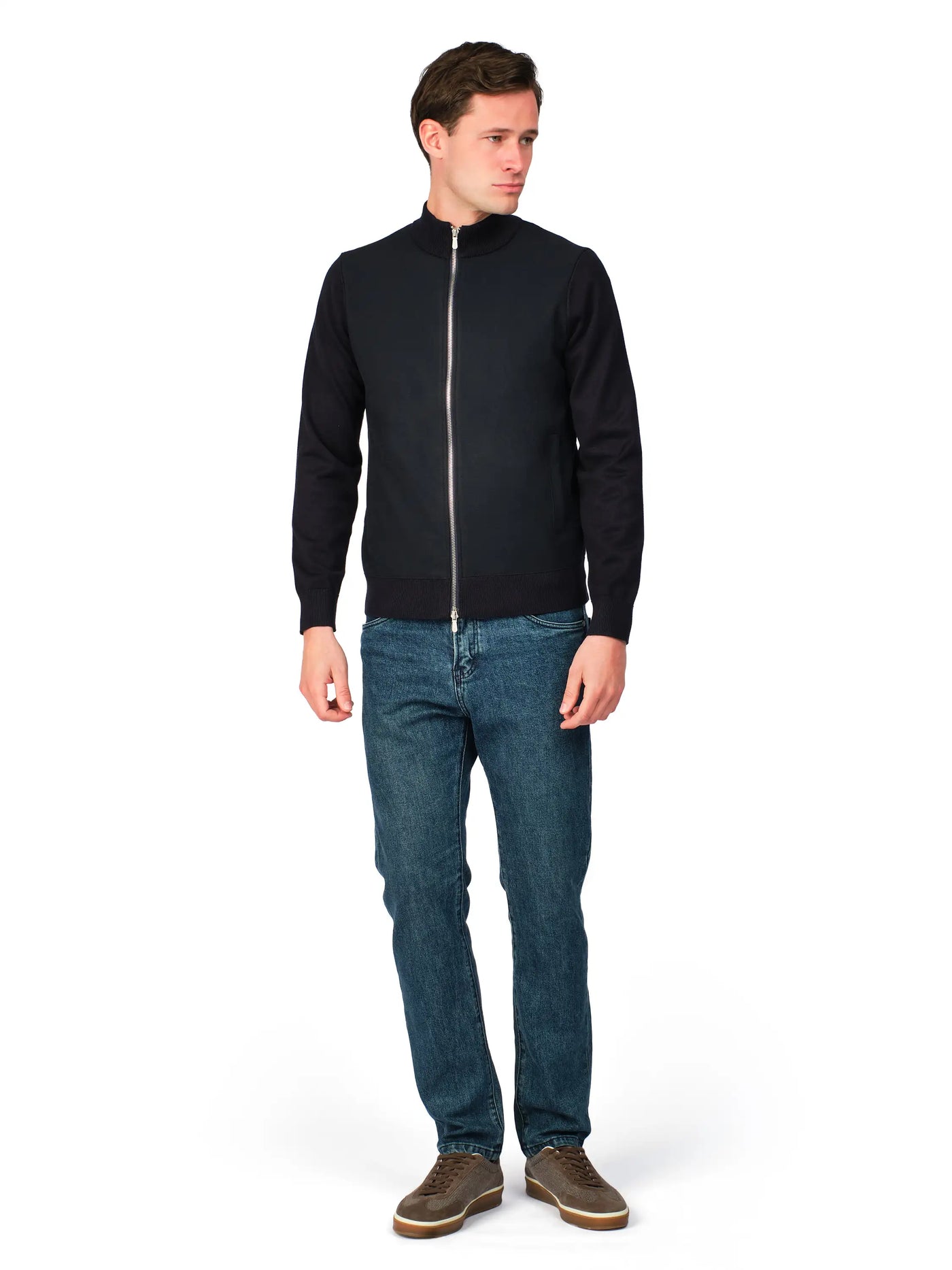 Man wearing a black jacket and blue jeans on a white background
