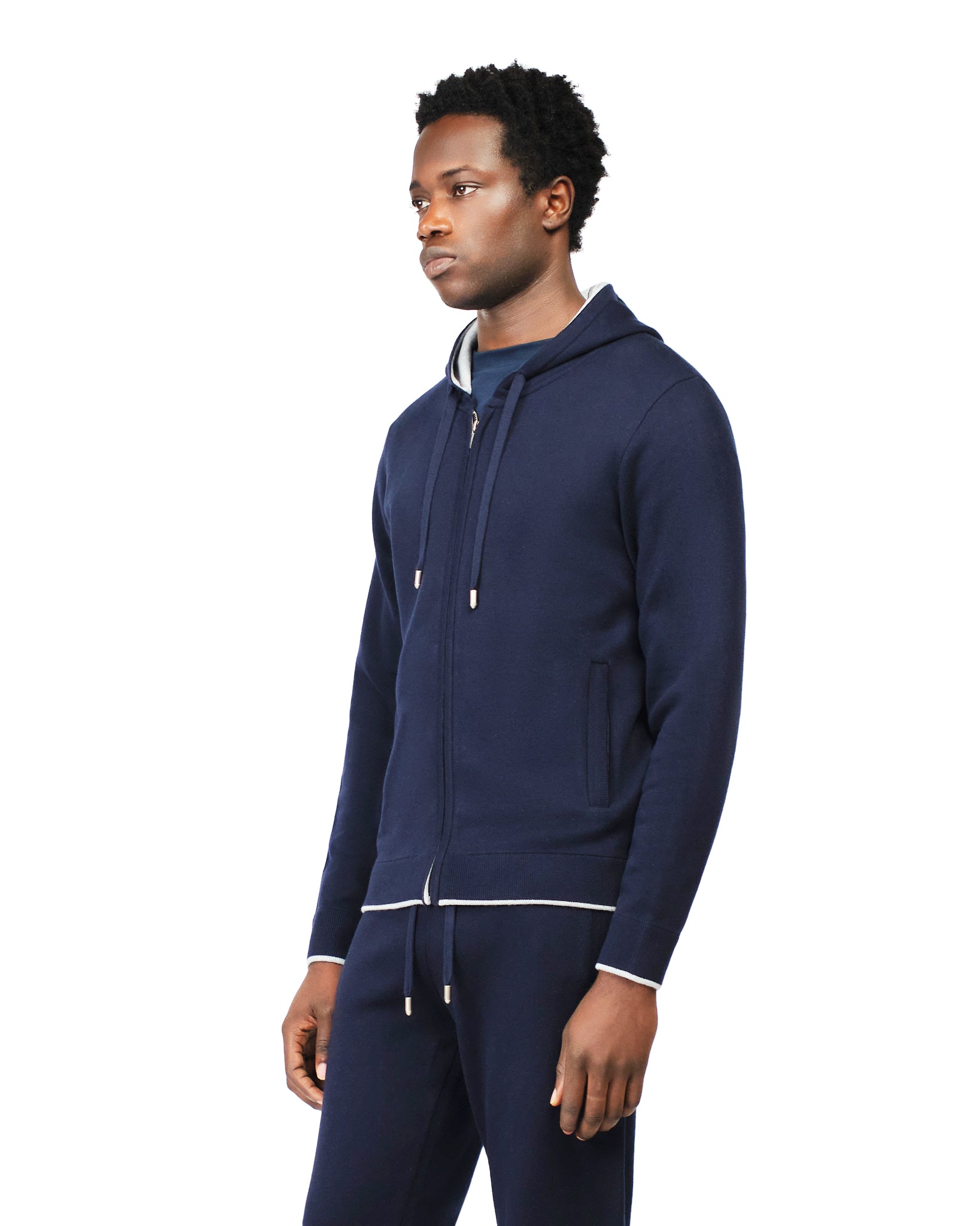 Man wearing a navy tracksuit on a white background
