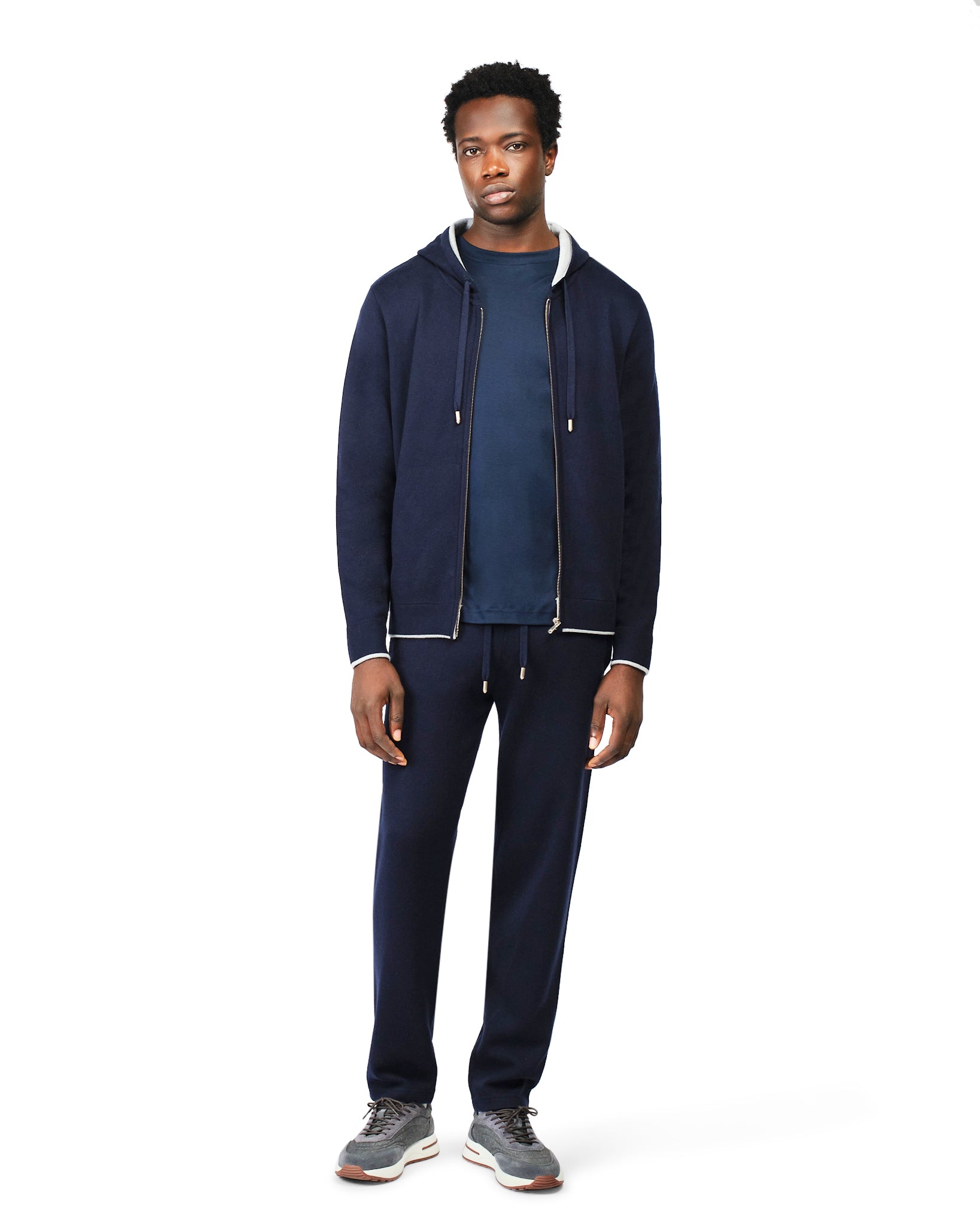 Man wearing a navy tracksuit on a white background