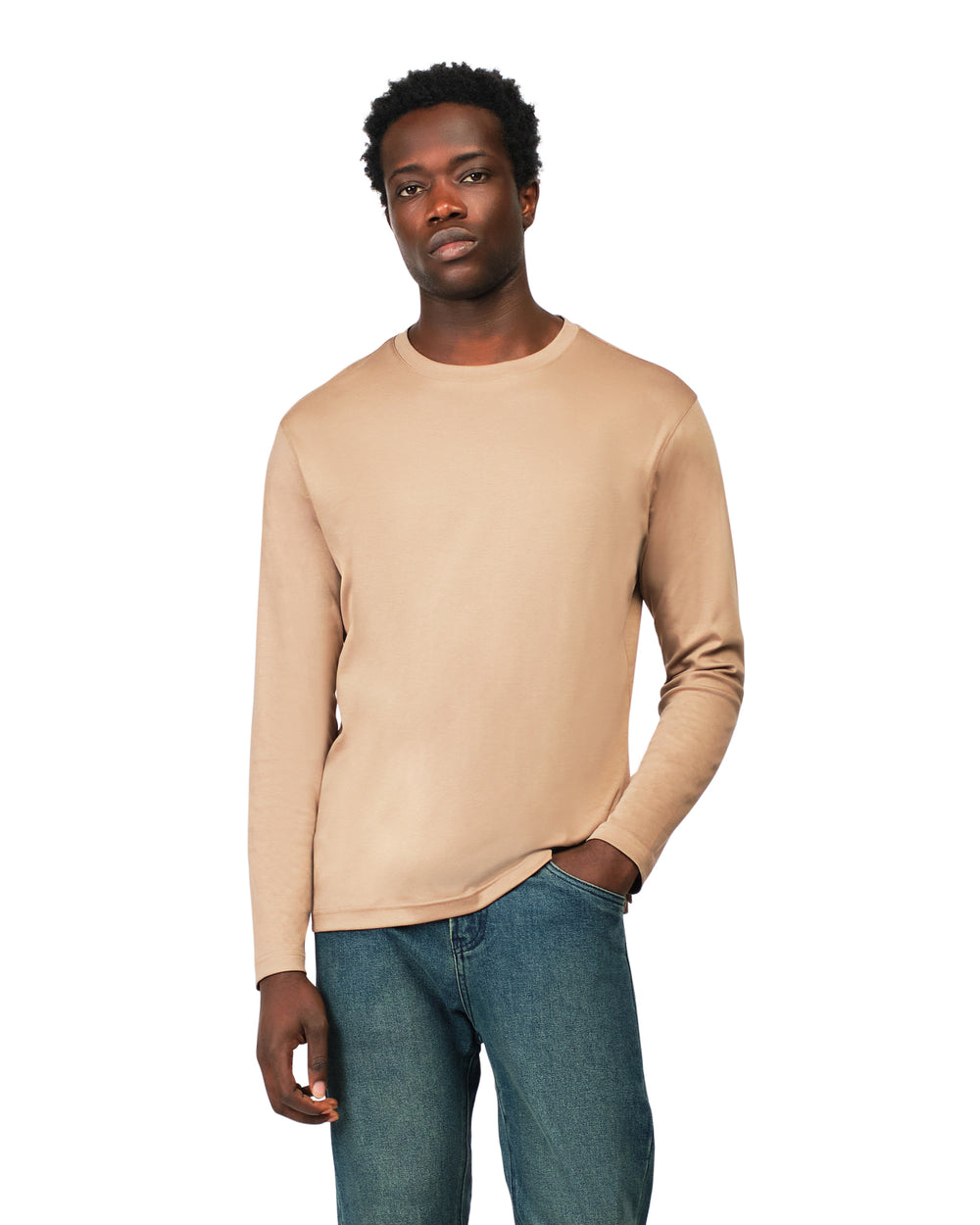 Man wearing a beige long-sleeve shirt and blue jeans on a white background