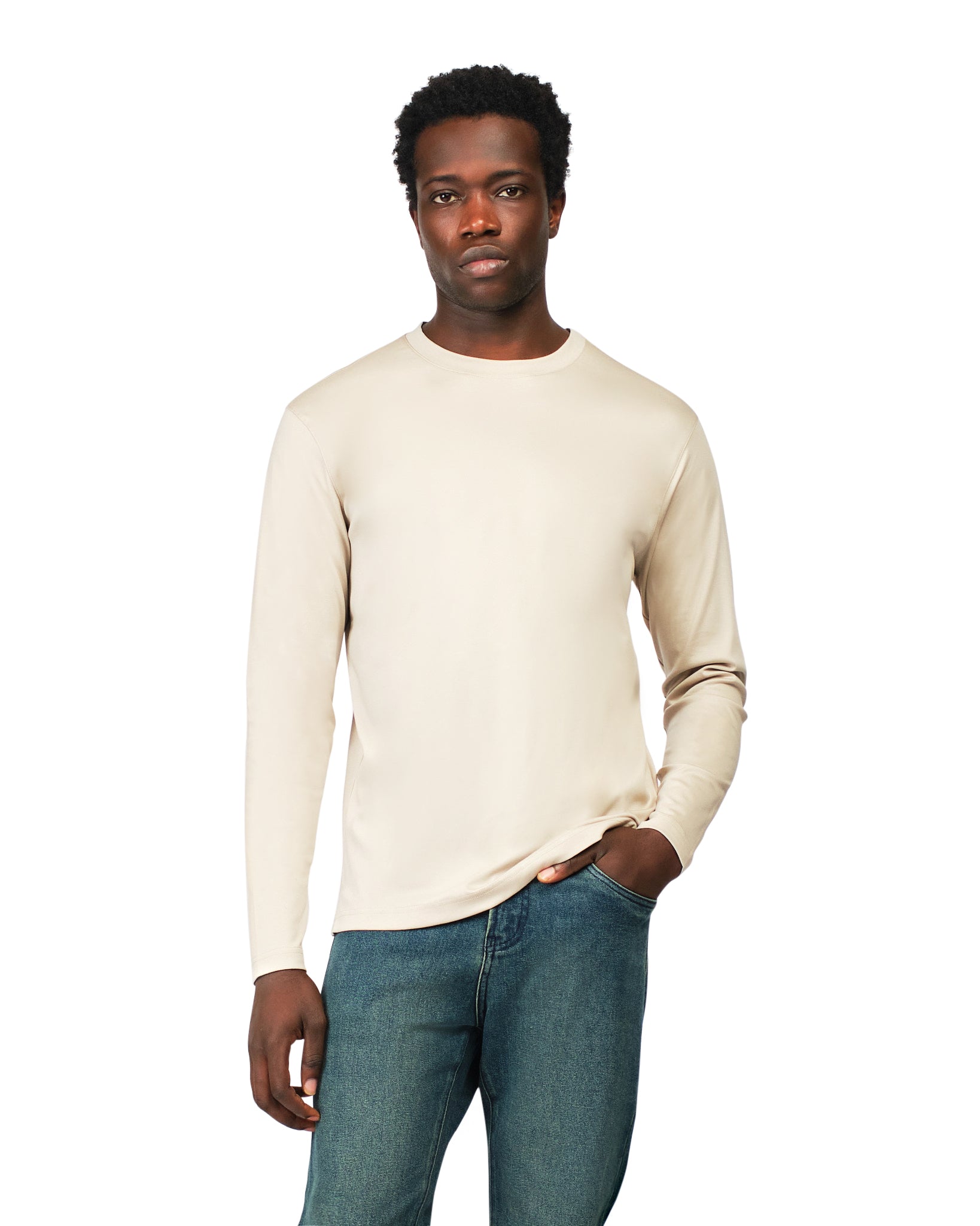 Man wearing a beige long-sleeve shirt and blue jeans on a white background