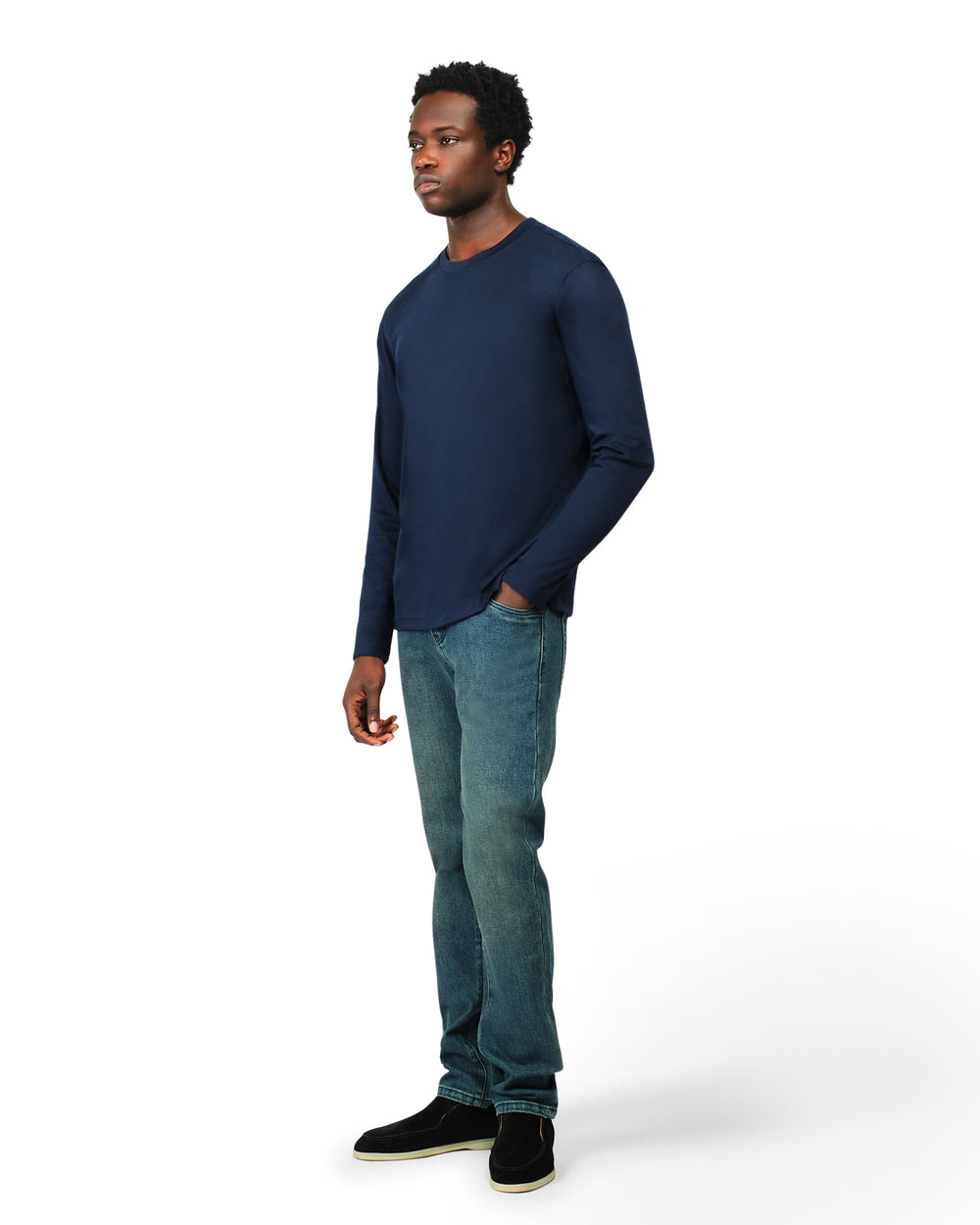 Man wearing a navy long-sleeve shirt and blue jeans on a white background