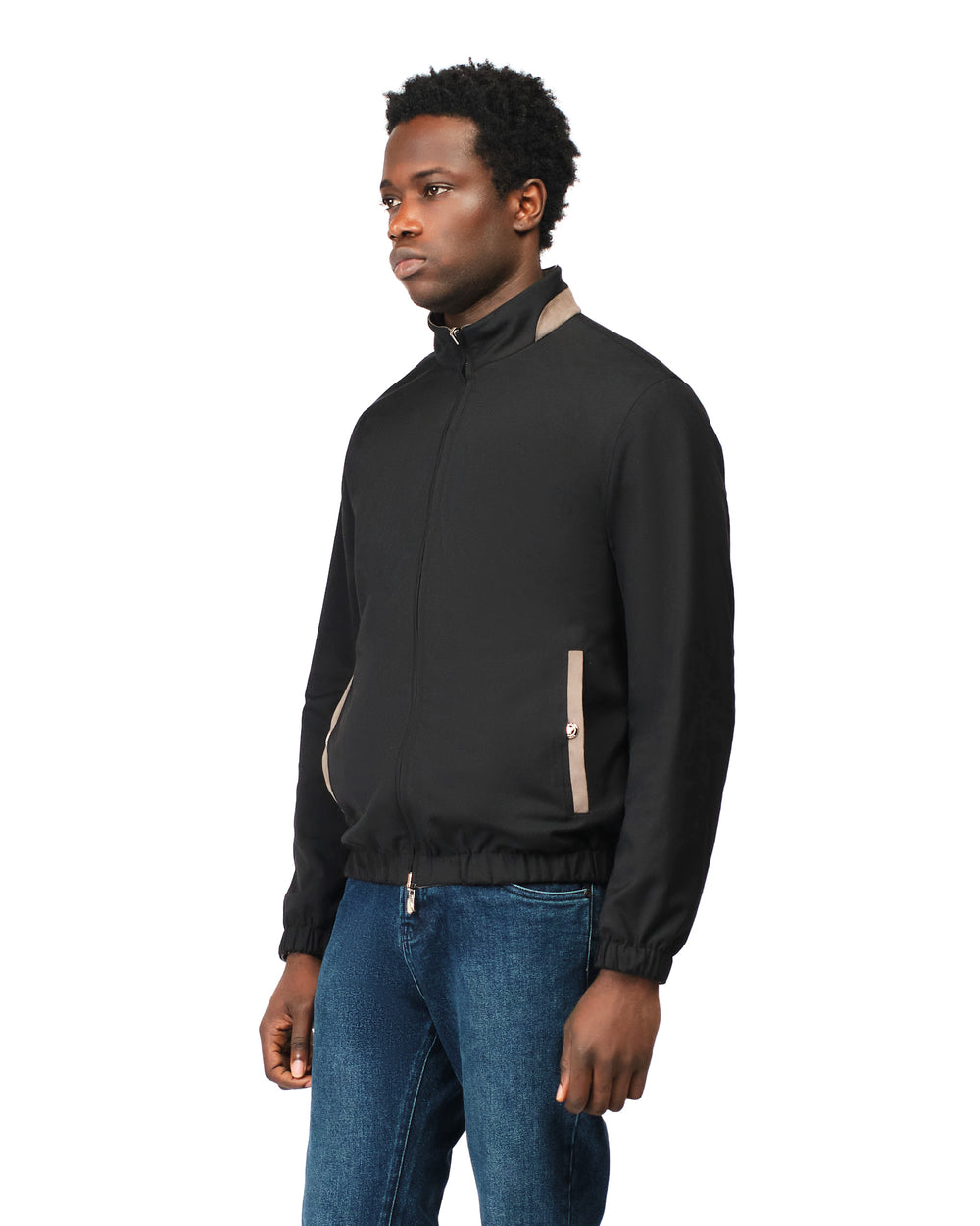 Man wearing a black quarter-zip sweatshirt and blue jeans on a white background