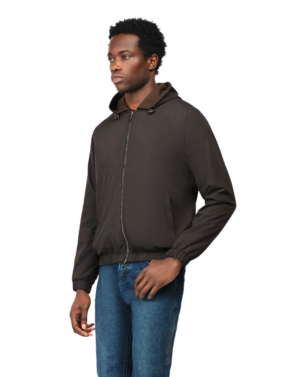 Man wearing a dark brown jacket and blue jeans on a white background