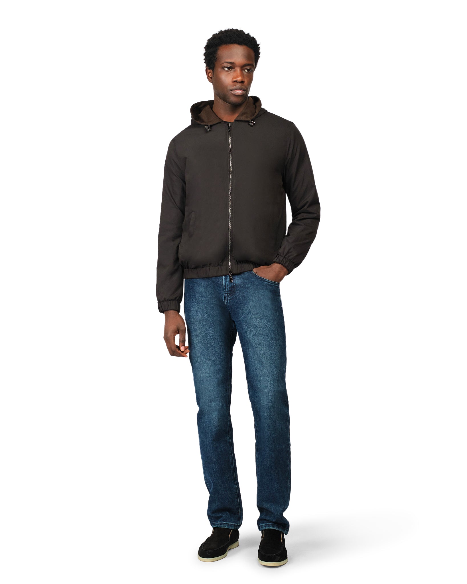 Man wearing a dark jacket and blue jeans on a white background