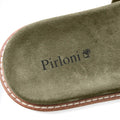 Close-up of a green suede shoe insole with the Pirloni brand name and logo printed in black, showing a brown and white welted edge on a white background.
