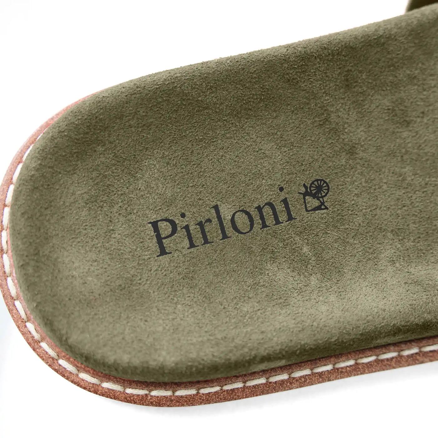 Close-up of a green suede shoe insole with the Pirloni brand name and logo printed in black, showing a brown and white welted edge on a white background.